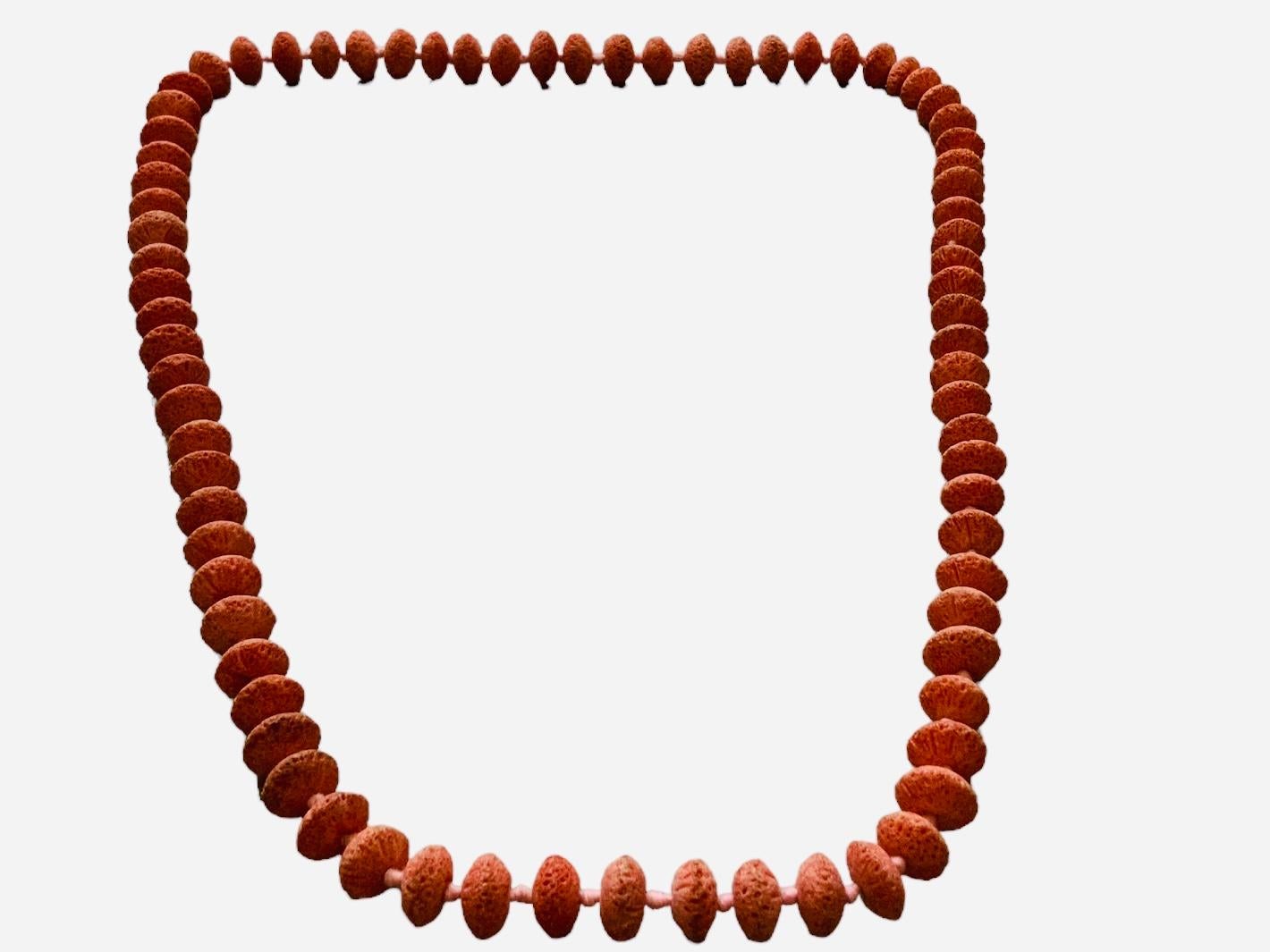 Questa è una collana Opera in corallo spugna rosa. Raffigura una lunga collana con perline di corallo rosa a forma di disco poroso. Le perle a disco di corallo spugna sono state infilate in un filo spesso e fermate con dei nodi. I coralli spugna non