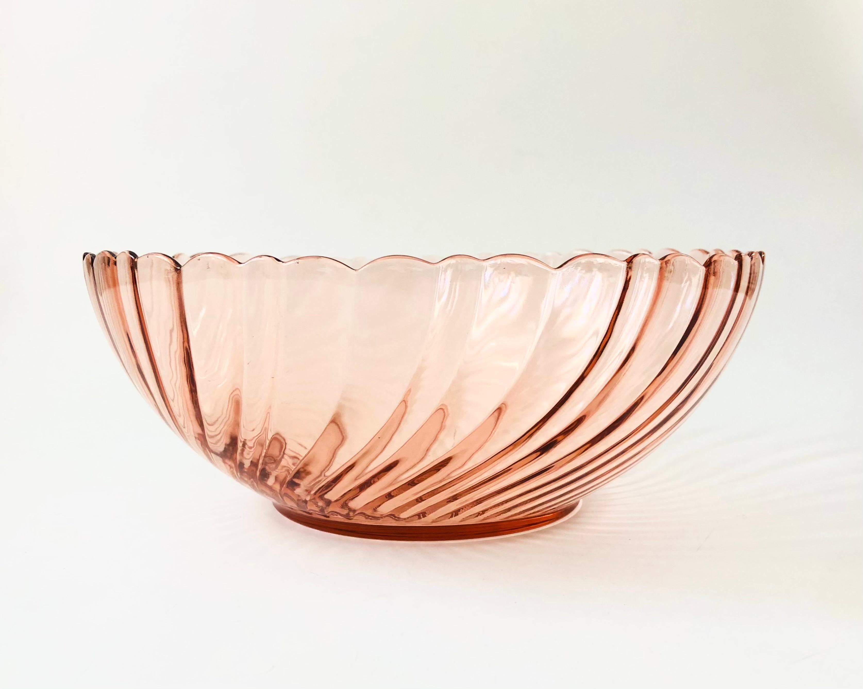 A large vintage glass salad bowl in a blush pink color. Beautiful swirl texture to the glass.  Made in France by Arcoroc in the rosaline swirl pattern.

