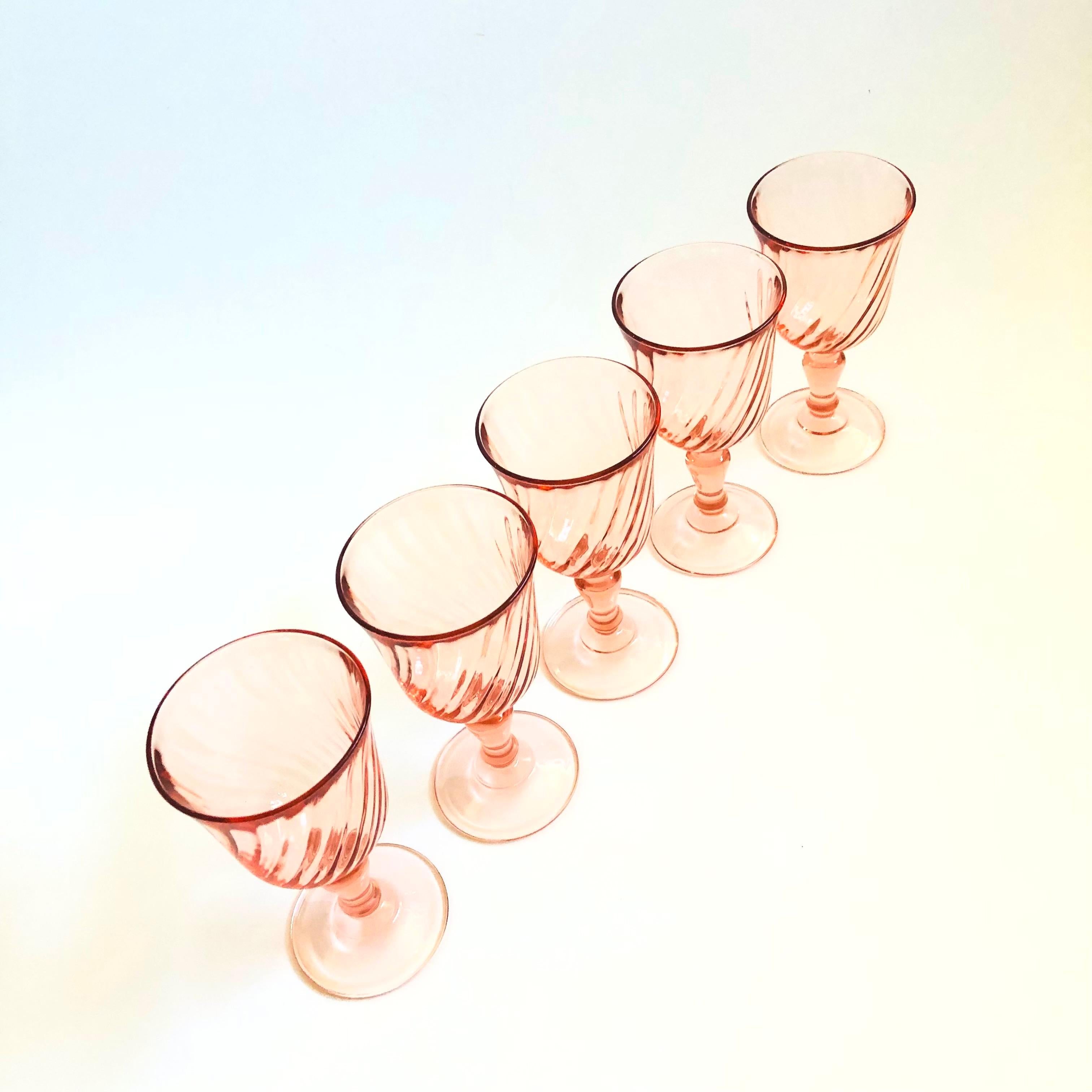Un set di 5 bicchieri da vino vintage in una tonalità rosa pallido. Ogni bicchiere presenta un grazioso disegno a volute. Prodotto in Francia da Luminarc.

