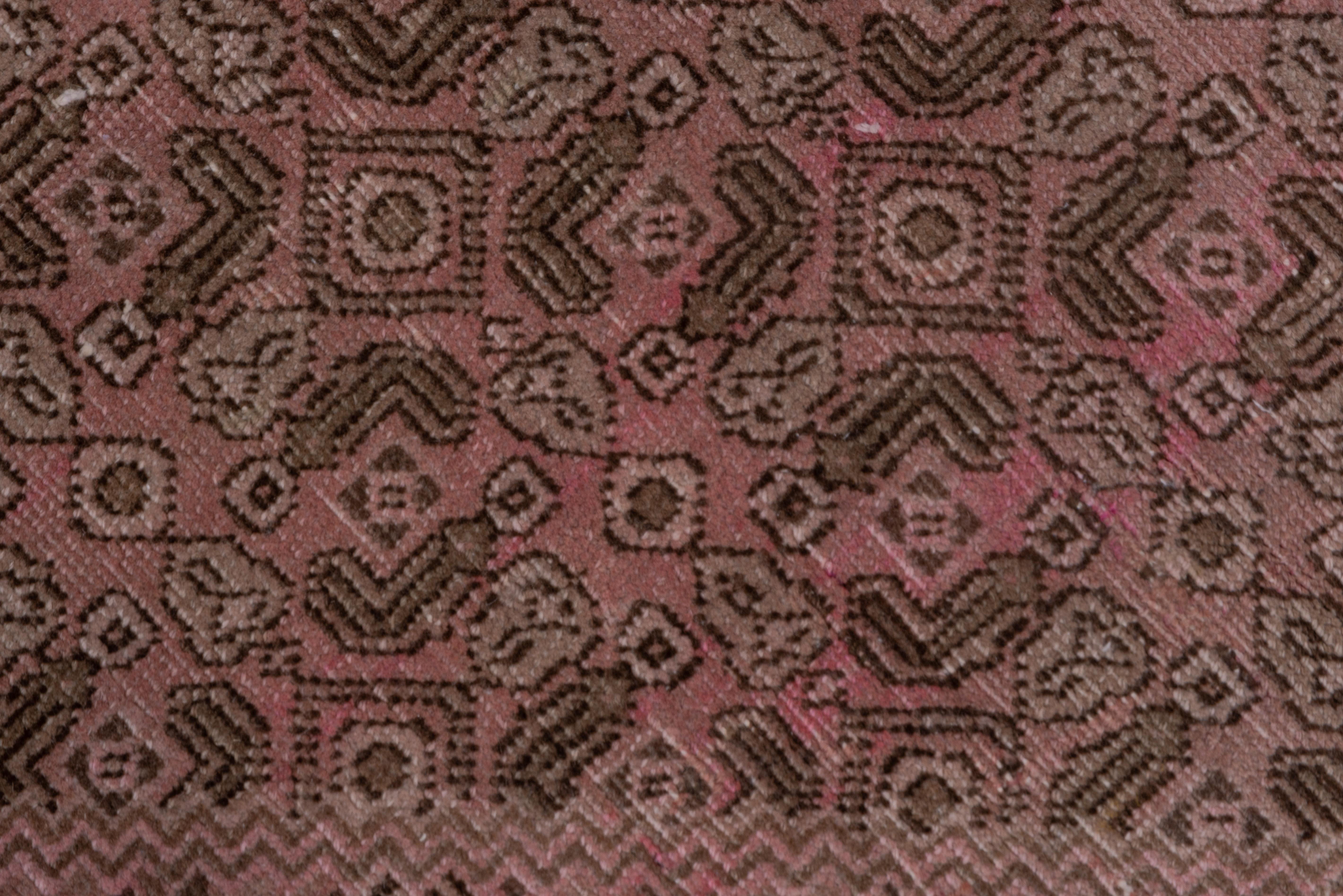 Ce tapis de ville du nord-ouest de la Perse, solidement tissé, présente un motif Herati caractéristique, stratifié et très simplifié, dans le sous-médaillon crème, le médaillon marron étagé qui l'entoure, le sous-champ beige, le champ marron rouille