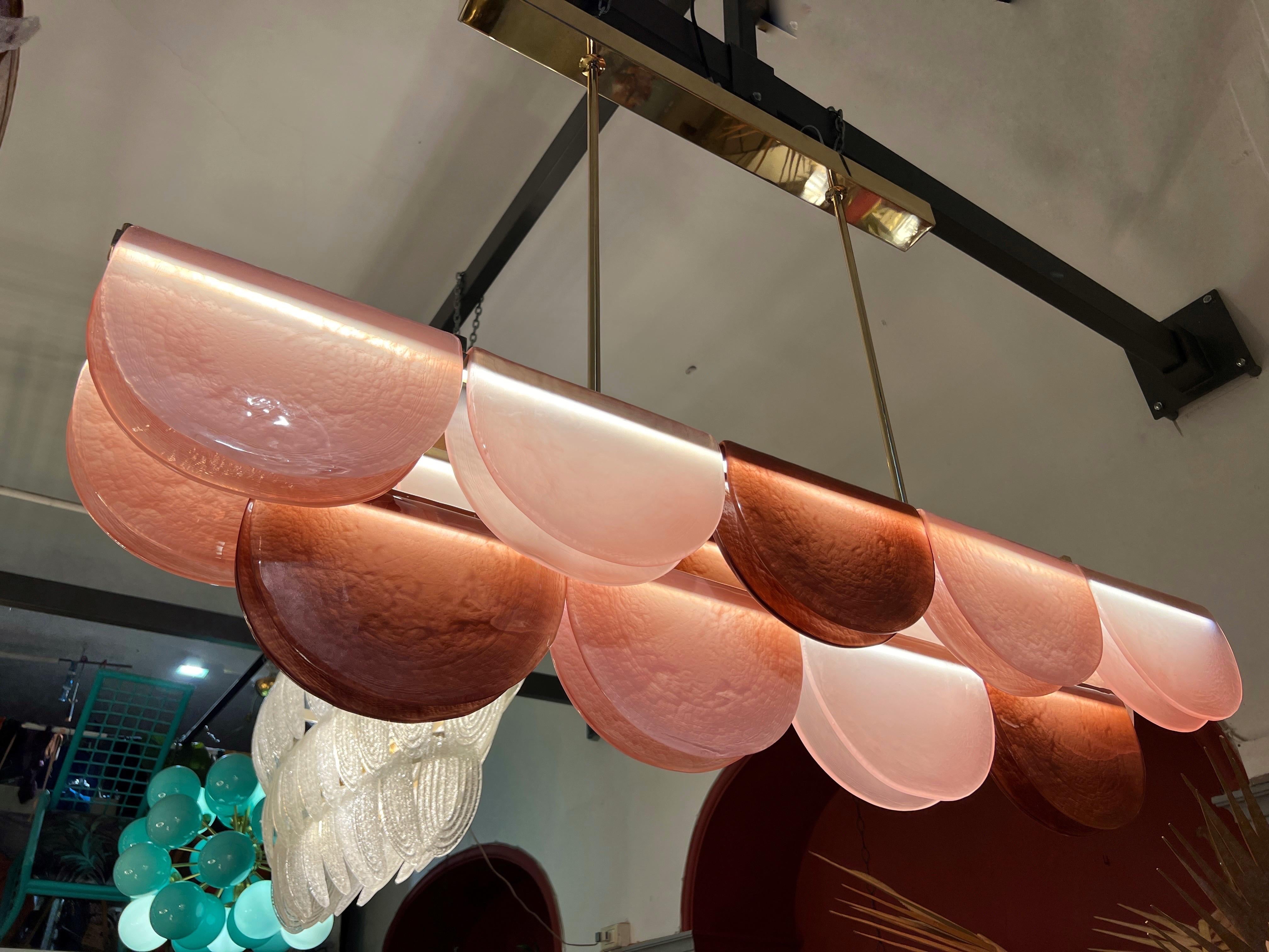 Lampadario in vetro di Murano dai toni rosa con 3 luci a led e struttura in ottone.
Il vetro di Murano pieghevole ha tre tonalità diverse (rosa pallido, rosa cipria e rosa bronzo).
Il lampadario è stato ricablato con 3 strisce led a luce diffusa e