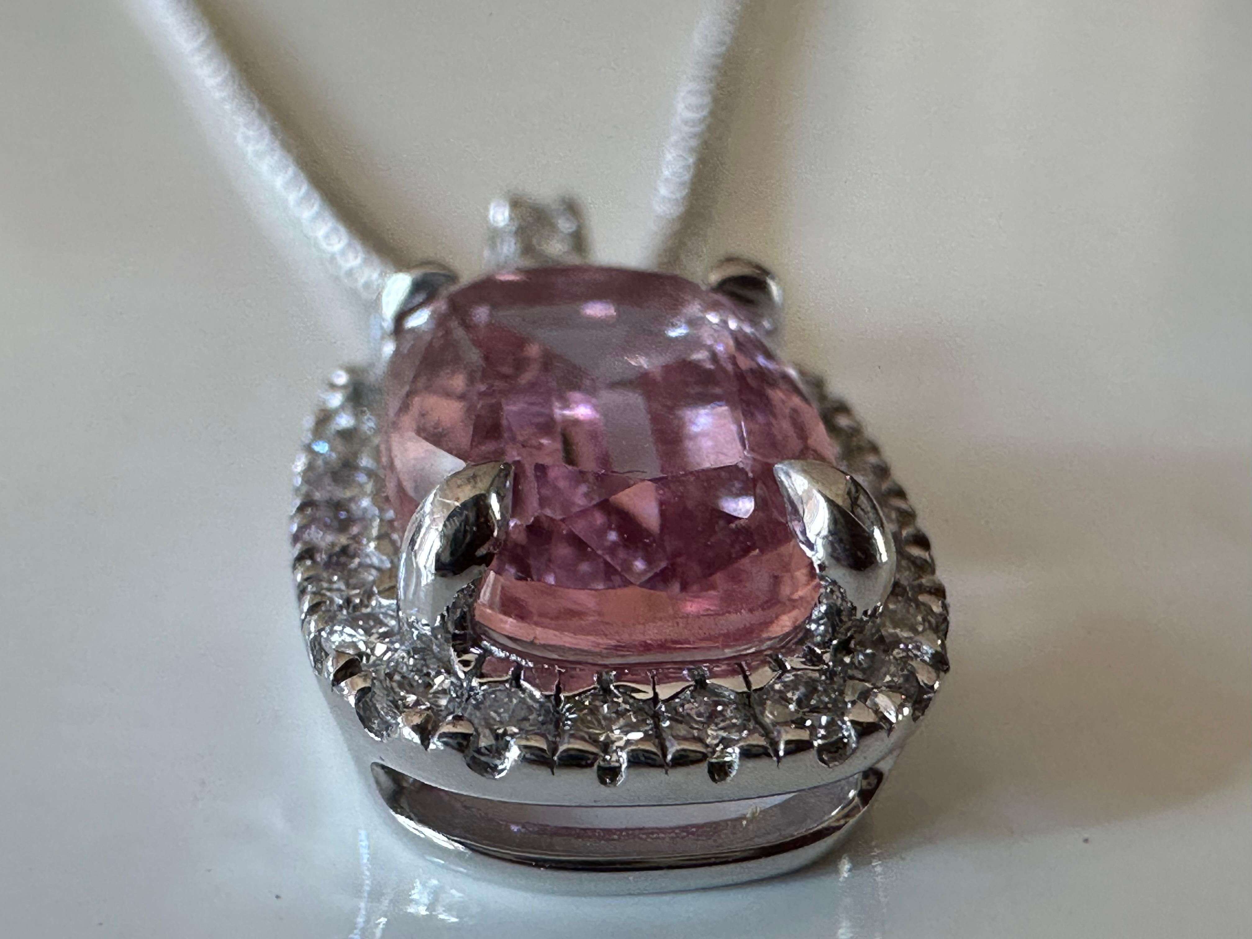 A 2.44-carat cushion-cut pink topaz centers this pendant necklace handcrafted in 14K white gold, surrounded by a halo of twenty-eight round diamonds, G color, SI1 clarity totaling 0.24 carats. The necklace measures 18 inches. 