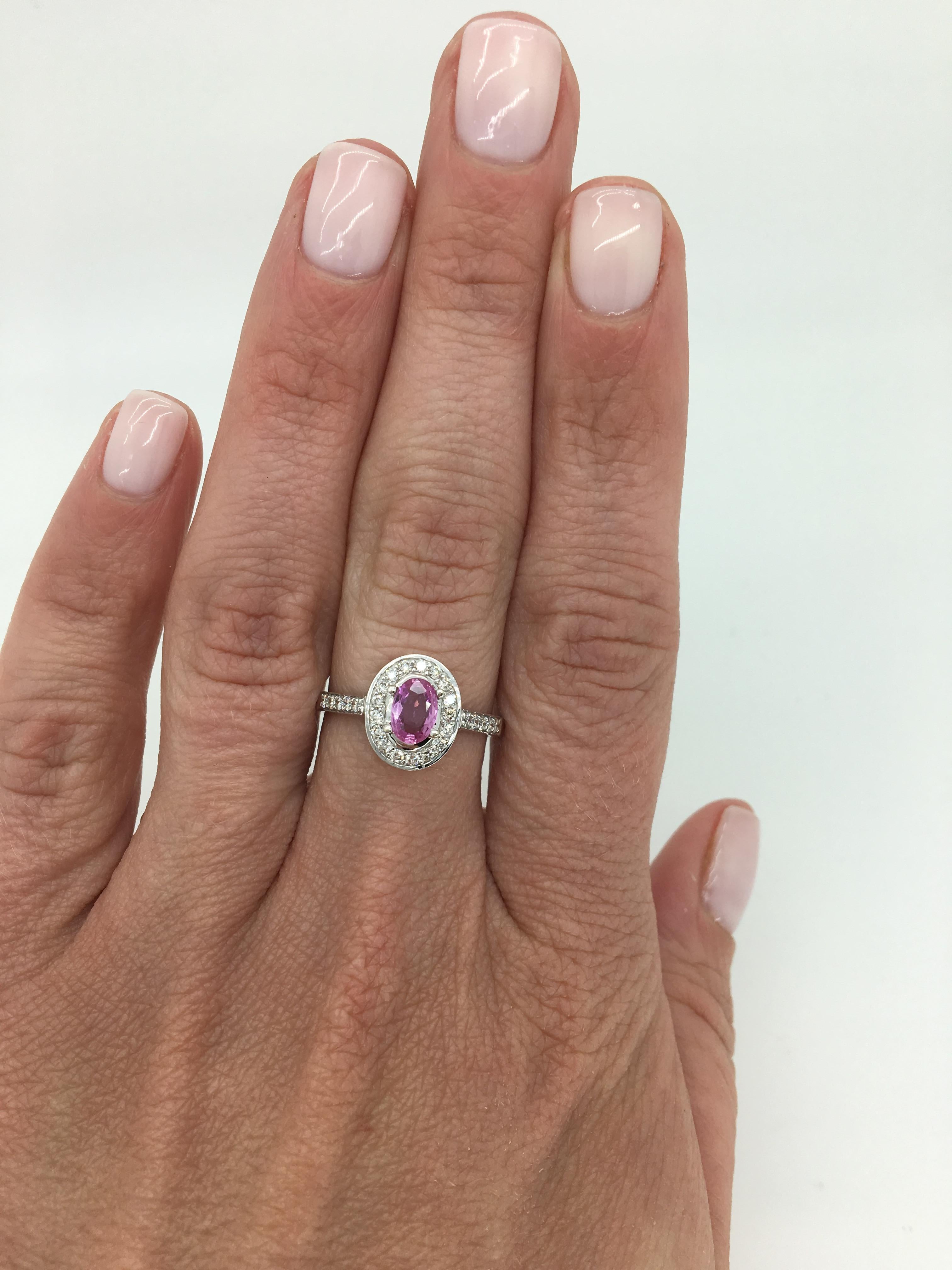 Halo style Pink Topaz and diamond ring. 

Gemstone: Pink Topaz and Diamond
Gemstone Carat Weight: Approximately .55CT Oval Cut
Diamond Carat Weight: Approximately .30CTW
Diamond Cut: Round Brilliant Cut
Color: Average G-I
Clarity: Average