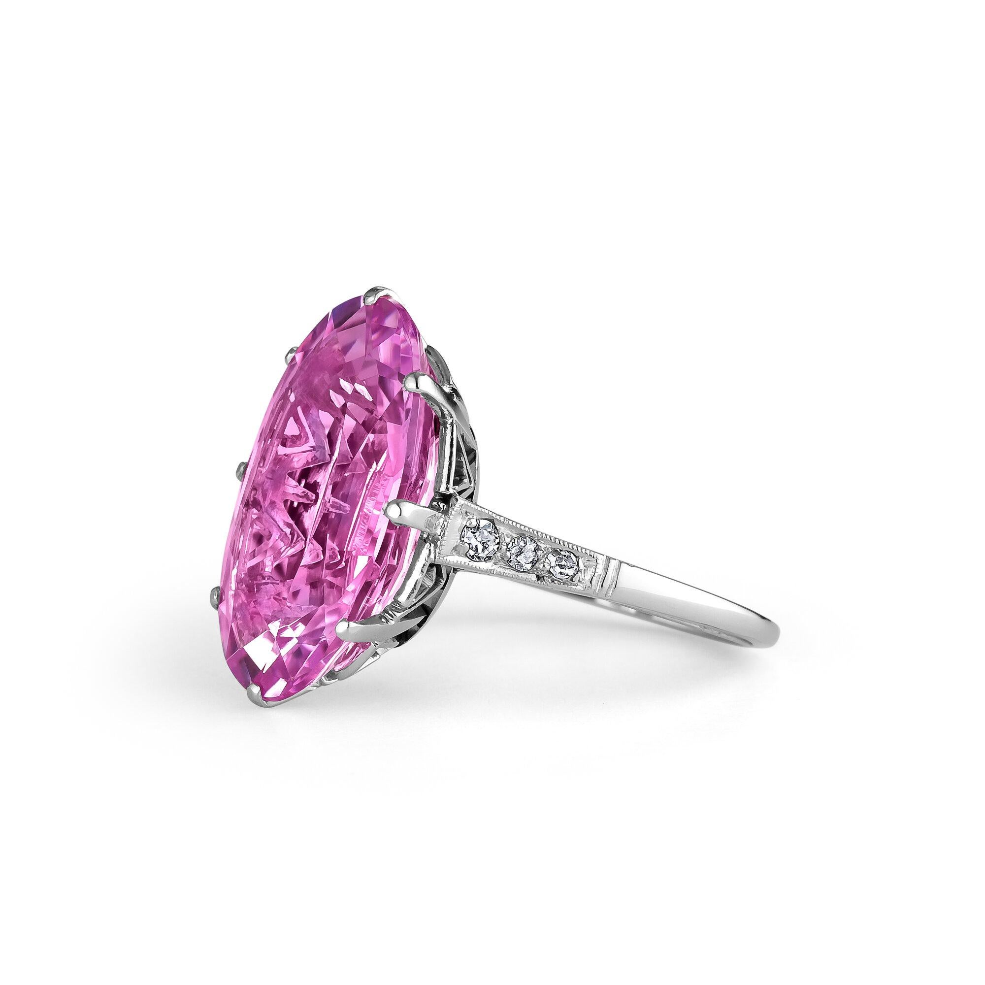 Prettier than any pink color could hope to be, this glimmering 12.51 carat oval cushion cut pink topaz gemstone flashes with lilac accents making it deliciously alive.  Mounted in an intricately designed vintage style diamond platinum setting, this