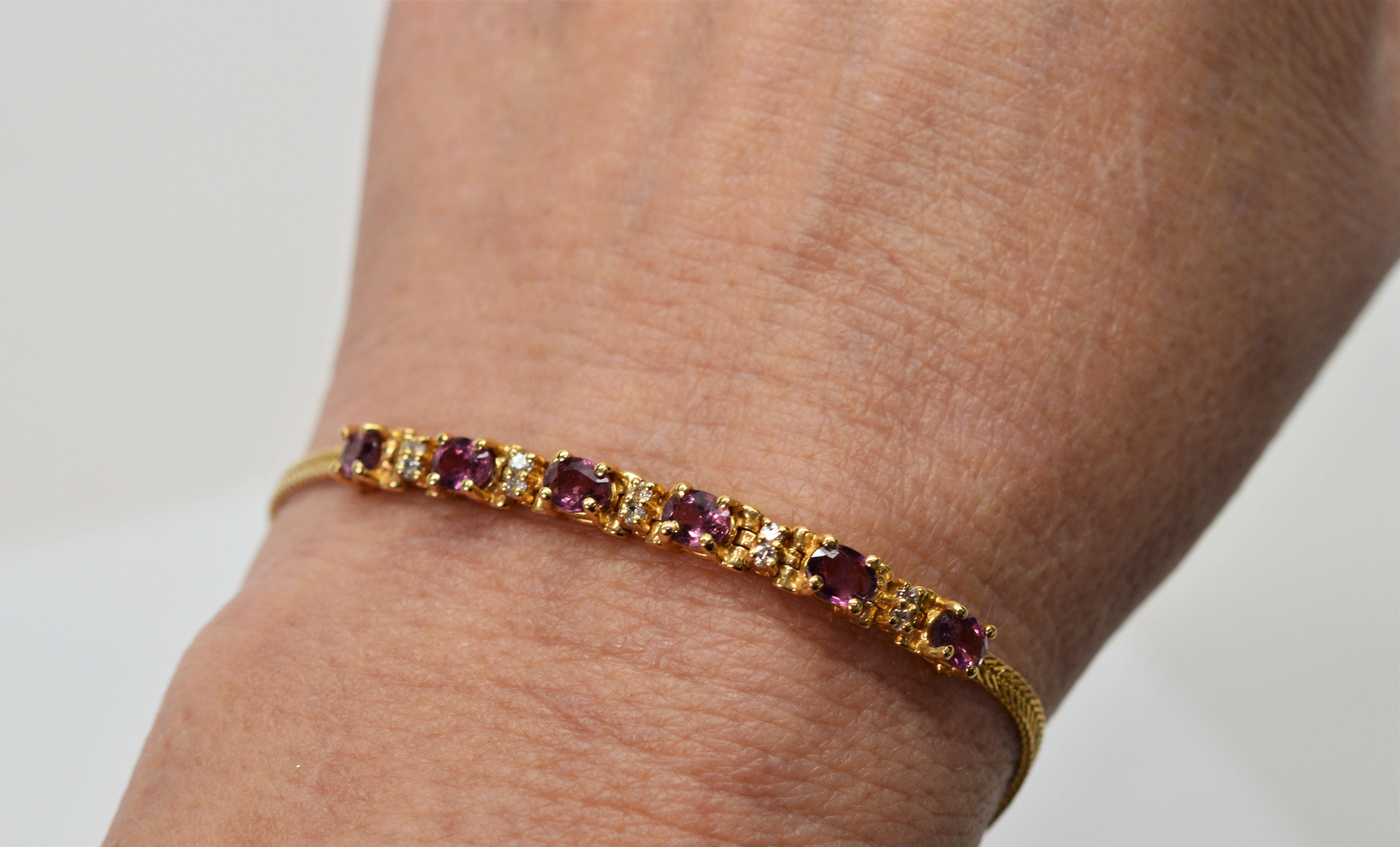 A crown of pink topaz accented with diamonds extends 1-6/8 inch across the face of this feminine bracelet.  In fourteen carat 14K yellow gold are six prong set pink topaz gemstones defined by five diamond stations of two each .005 carat stones and