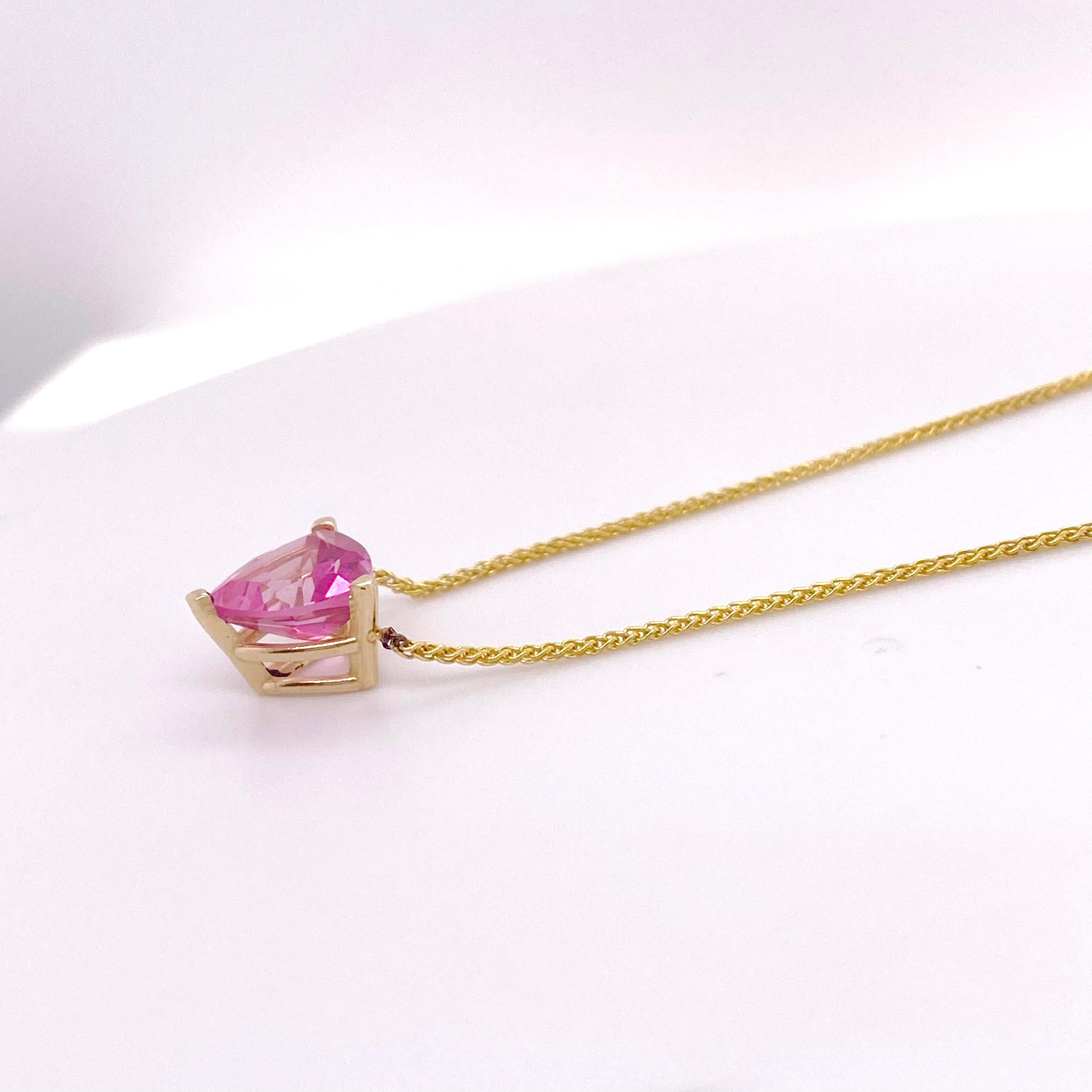 Pink, bright pink, topaz that is a massive 5.50 carat, trillion shape. This fabulous specimen of pink topaz is a very pure color. It is set in a three prong basket with a wheat chain.  This necklace will look amazing on you or your loved one! The