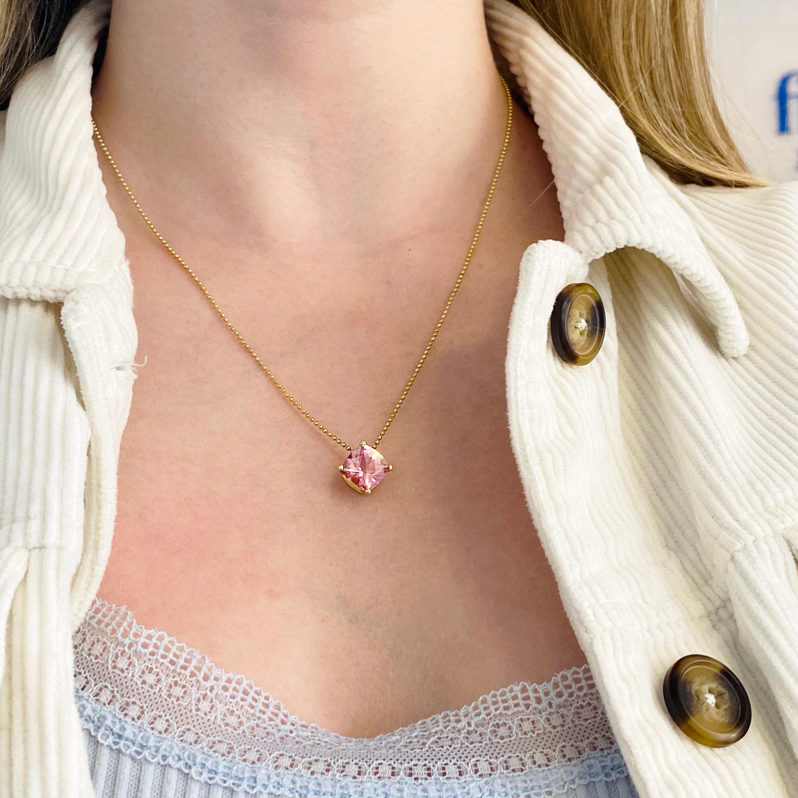 The cushion shaped pink topaz is gorgeous set on point in a simple basket setting. The gold beaded chain is attached to either side and hangs perfectly! The details for this beautiful necklace are listed below:
Metal Quality: 14 Kt Yellow