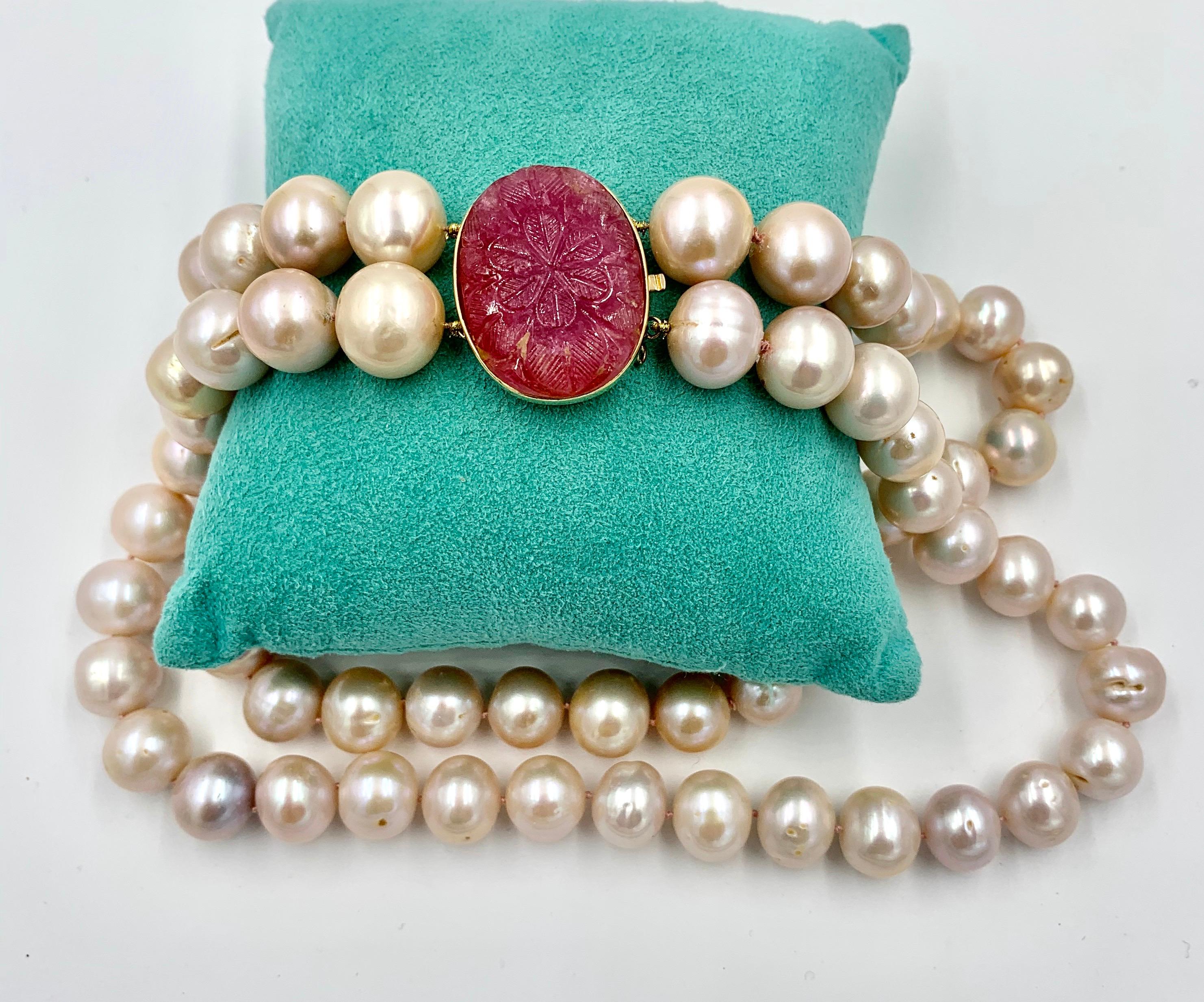 AN EXTRAORDINARY NECKLACE FROM THE ESTATE OF JANINE METZ, THE SOCIAL SECRETARY TO THE DUCHESS OF WINDSOR.  THE NECKLACE IS A 16 INCH DOUBLE STRAND OF PINK FRESHWATER PEARLS WHICH RANGE IN SIZE FROM 14.1MM TO 12.5MM.  THE CLASP IS A GORGEOUS CARVED