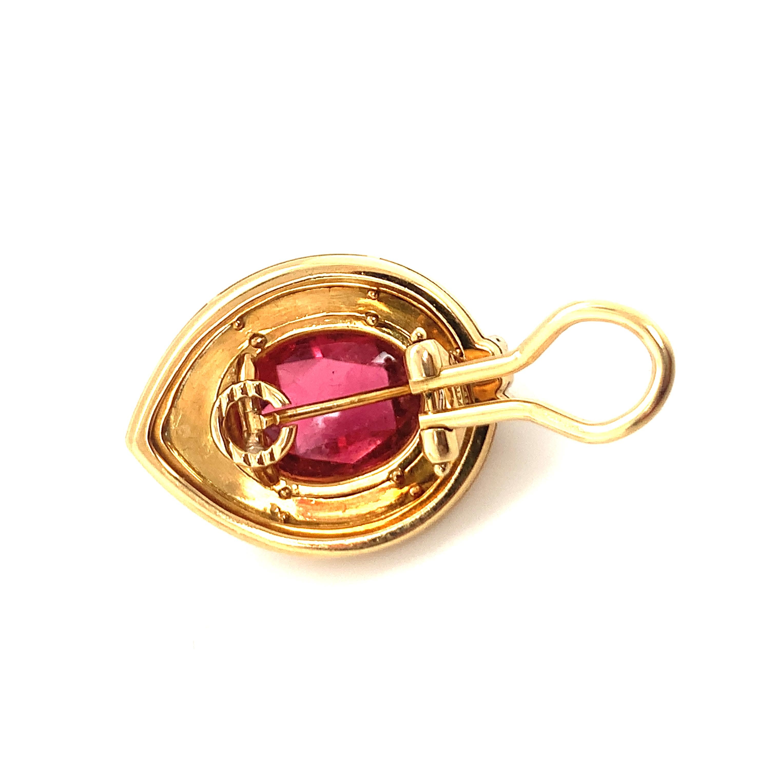 One pair of pink tourmaline 18K yellow gold earclips featuring two bezel set, multi-faceted mixed oval cut pink tourmalines weighing 12 ct. in total and measuring 13 x 10 millimeters in size. The earrings feature a multi-level, high polish gold