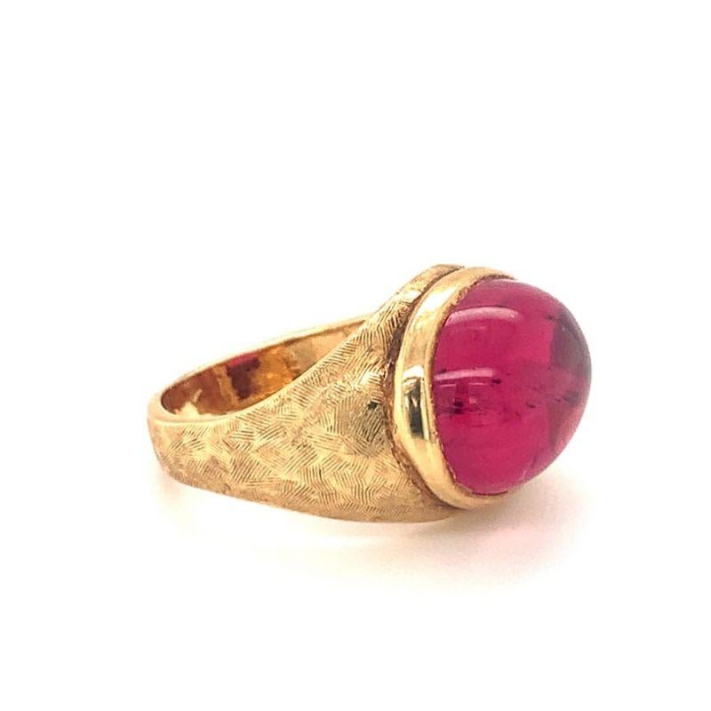One pink tourmaline 18K yellow gold ring featuring one bezel set, oval cabochon pink tourmaline weighing approximately 12 ct. with a heavily textured gold finish mount.

Pristine, enchanting, florid.

Additional information:
Metal: 18K yellow