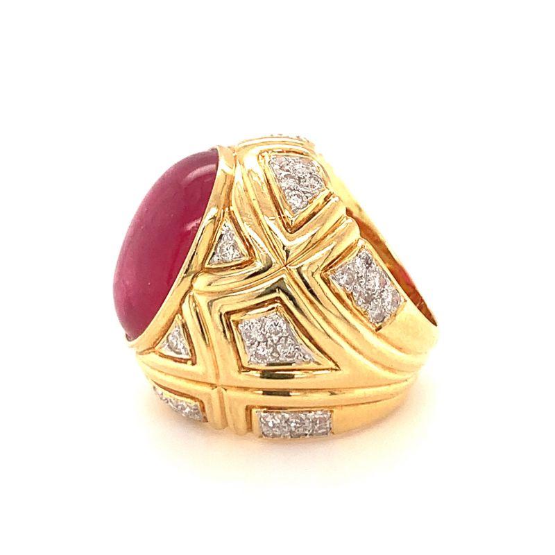 One pink tourmaline and diamond dome ring in 18K yellow gold centering one bezel set, oval cabochon cut pink tourmaline with an approximate weight of 16 ct. The ring features a geometric patterns and is enhanced by 56 round brilliant cut diamonds