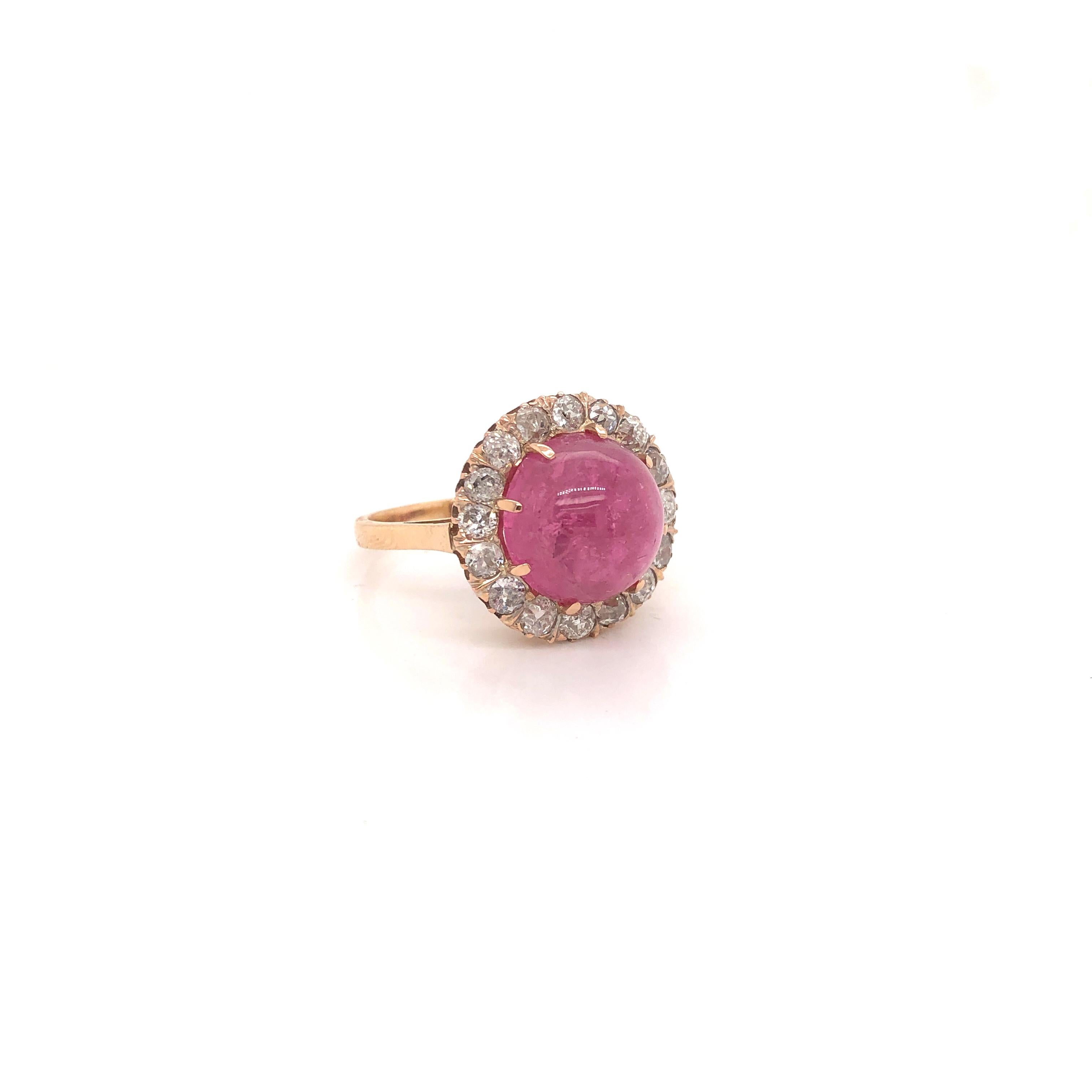This estate ring is a true beauty. Vivid pink color is seen in this cabochon cut Pink Tourmaline. The ring is crafted in 18k rose gold. Surrounding the main stone is a diamond halo.  The diamond halo is set with all old mine cut diamonds,