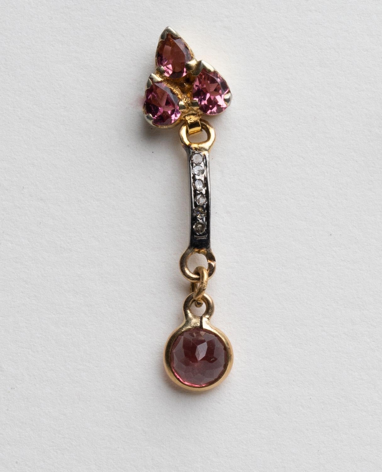 Three pear-shaped, faceted pink tourmalines are set in 18K gold on the earring's post.  A line of round, brilliant cut diamonds run down the spine of the earring, set in an oxidized sterling silver and the drop is a round, faceted pink tourmaline