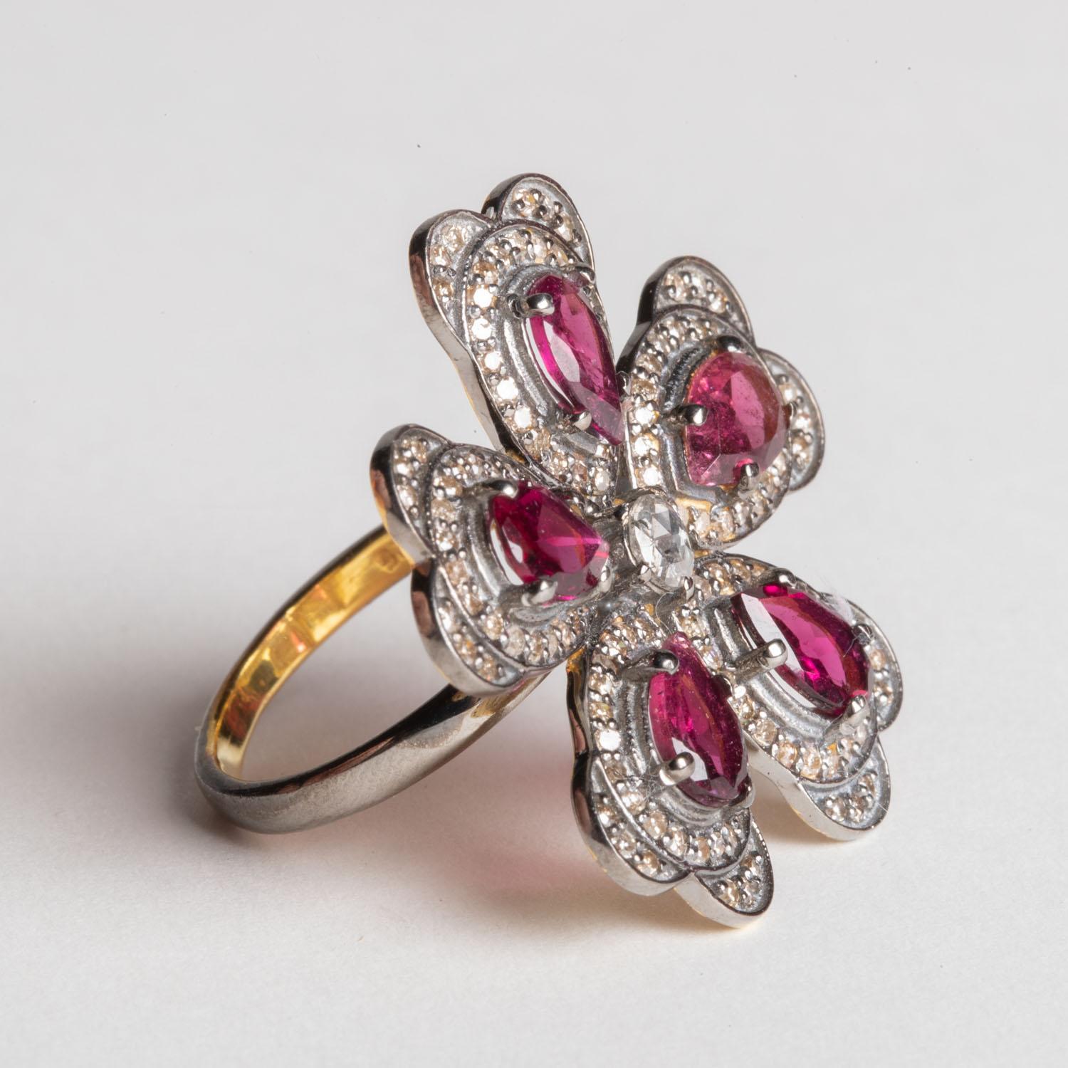 Ein schöner Cocktailring mit 5 birnenförmigen rosafarbenen Turmalinen, umgeben von Blütenblättern aus Diamanten in einer Pave`-Fassung, und einem facettierten runden Diamanten in der Mitte.  Das Gesamtkaratgewicht der Diamanten beträgt 0,94, das der