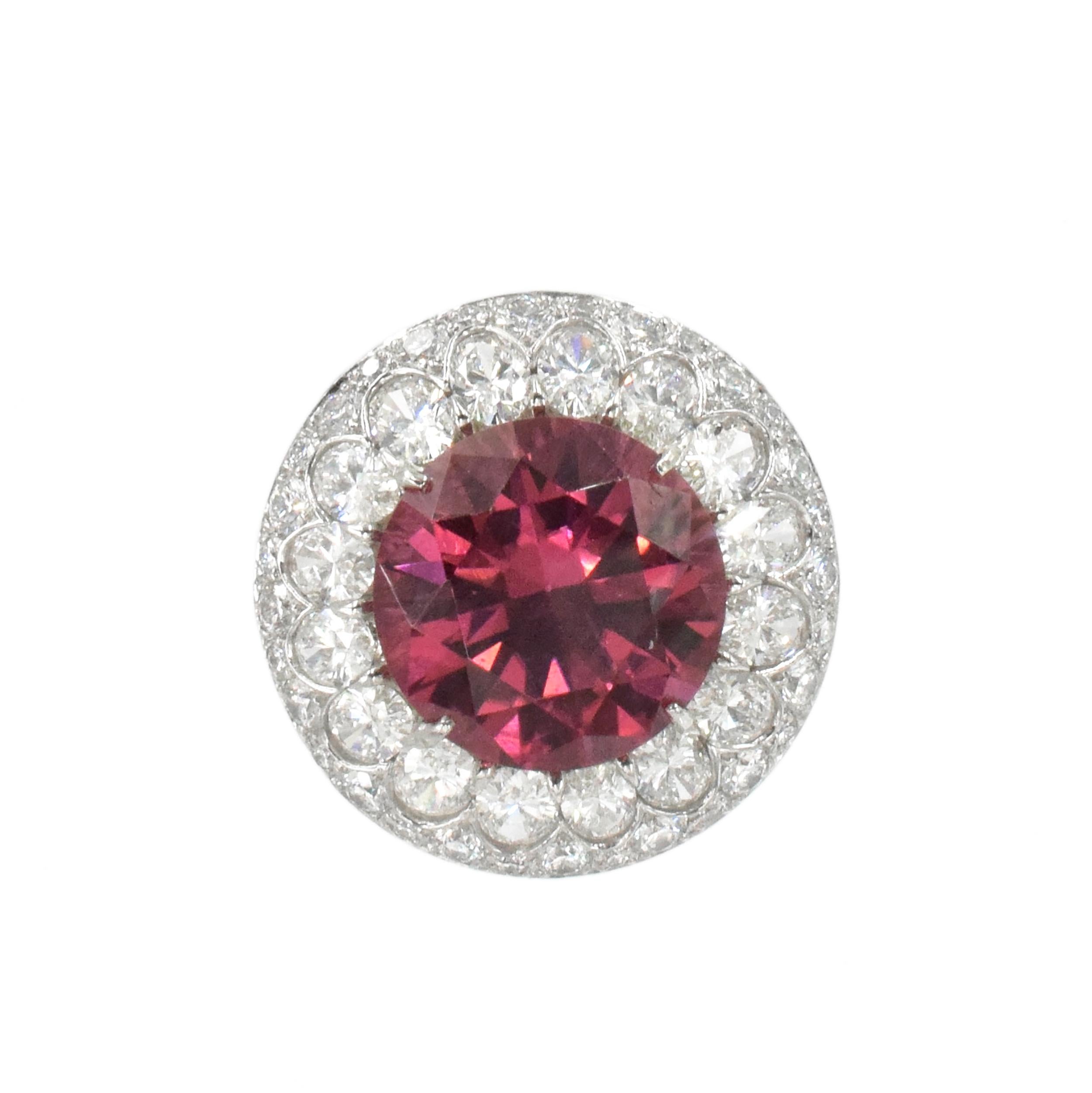 Pink tourmaline and diamond ring in platinum. Center of this ring is set with round brilliant cut pink tourmaline with total weight of approximately 8 carats (very rich color.) Surrounded by double halo of 16 oval cut diamonds and round diamonds on