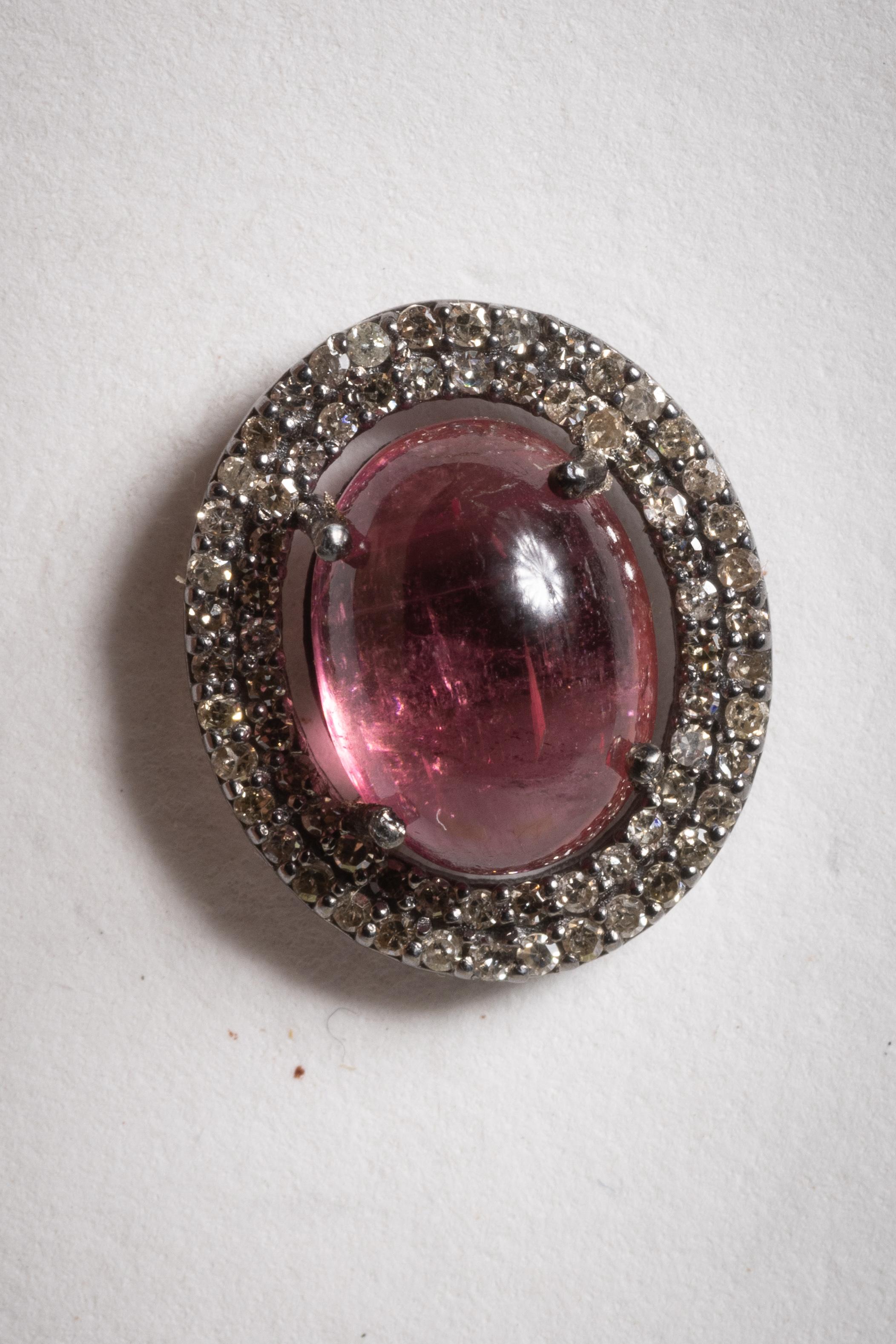 Une paire de boucles d'oreilles classique mais inhabituelle, composée de tourmalines roses ovales en cabochon, bordées d'une double rangée de diamants ronds de taille brillant en sertissage pavé.  Monté en argent sterling et avec des tenons en or 18
