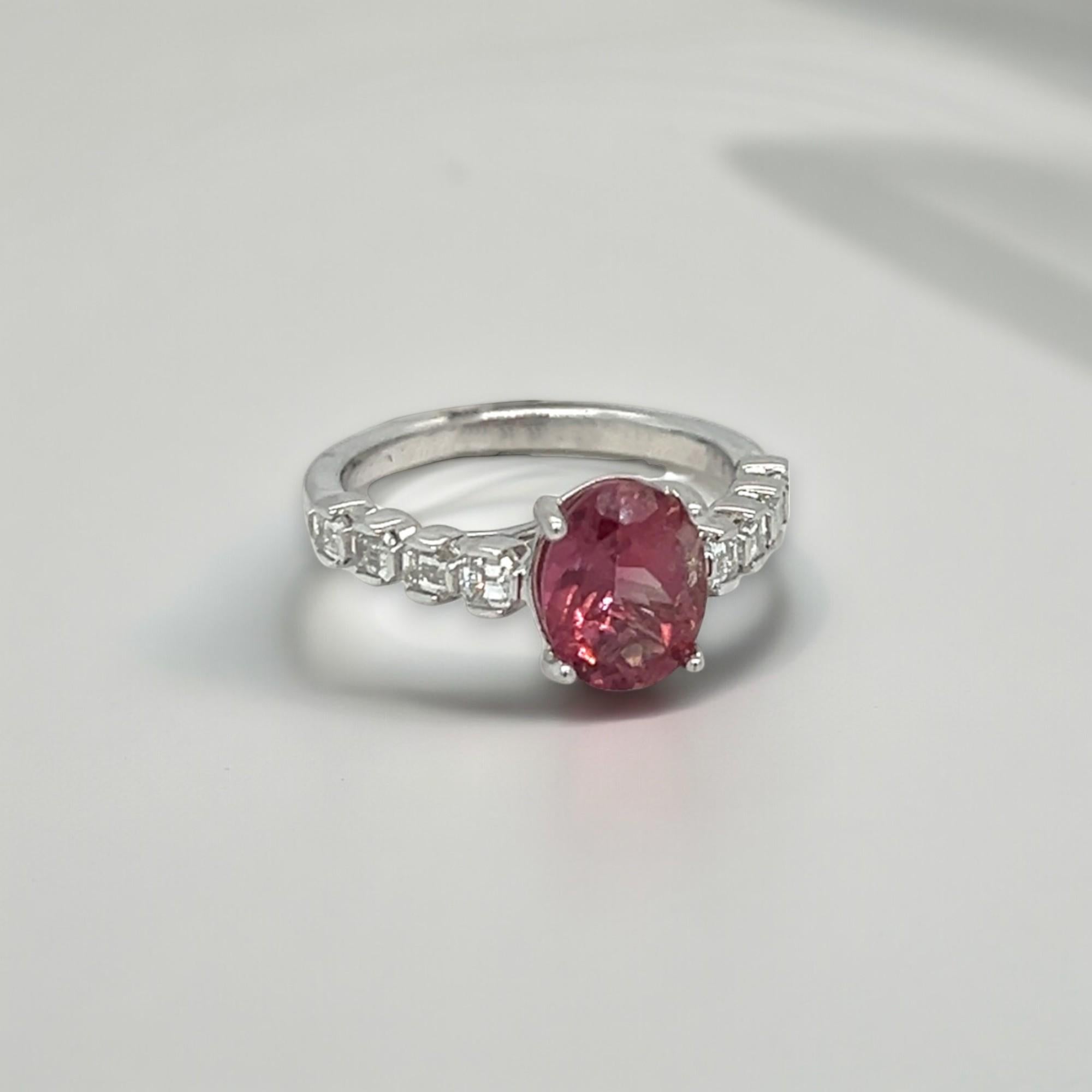 Questo splendido anello presenta una pietra centrale ovale di tormalina rosa di 1,92. La fascia in oro bianco 14k ha bellissimi diamanti taglio smeraldo (peso totale 0,71 ct) di colore G/H e purezza VS. L'anello può essere dimensionato al momento