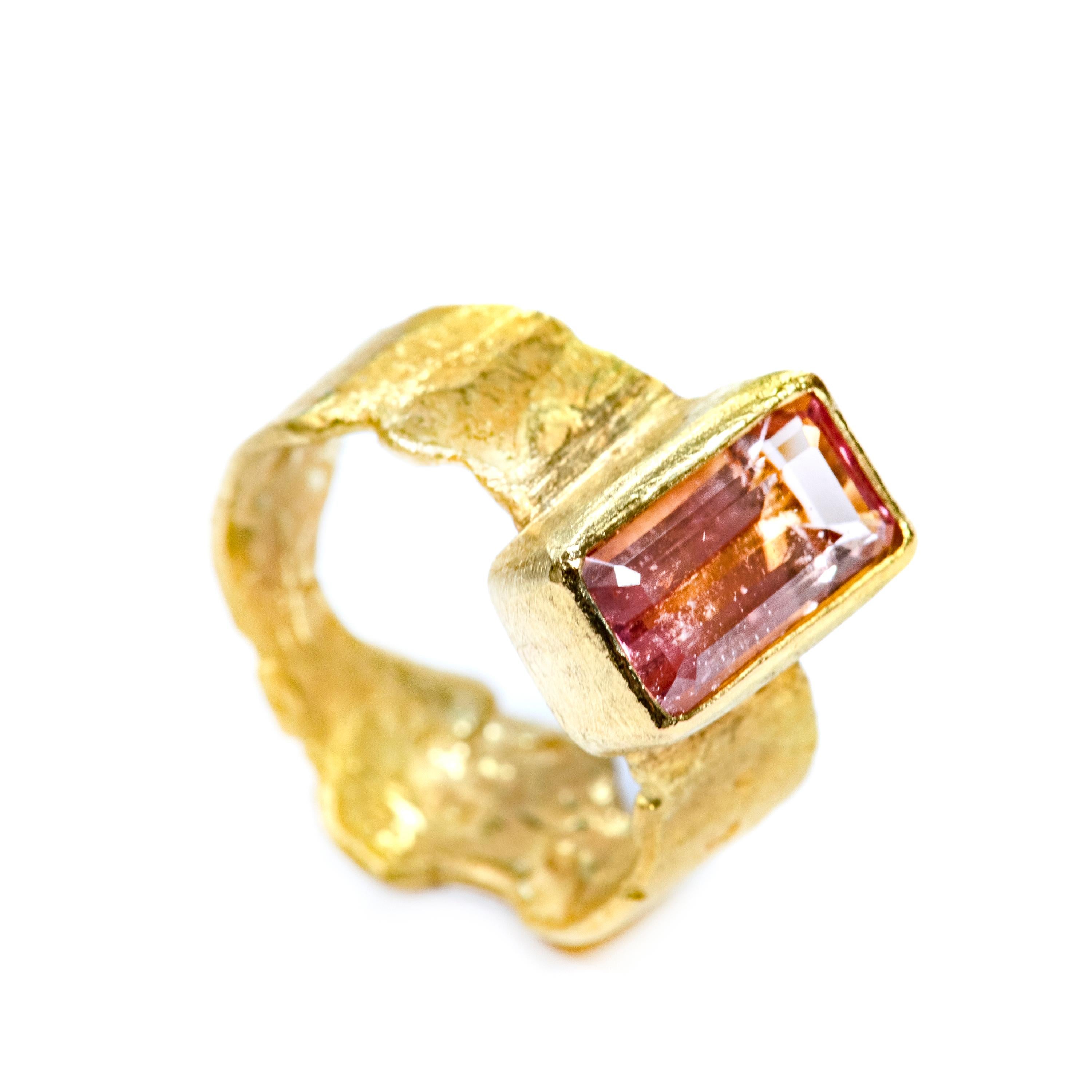 18k gold, organic hammered band with a 2.78ct baguette shaped pink tourmaline.

The band narrows at the back for comfort, 8mm at widest point, 4mm narrowest. The gem stone is 7x12mm with a 6mm depth from finger.

Disa Allsopp makes by hand each ring