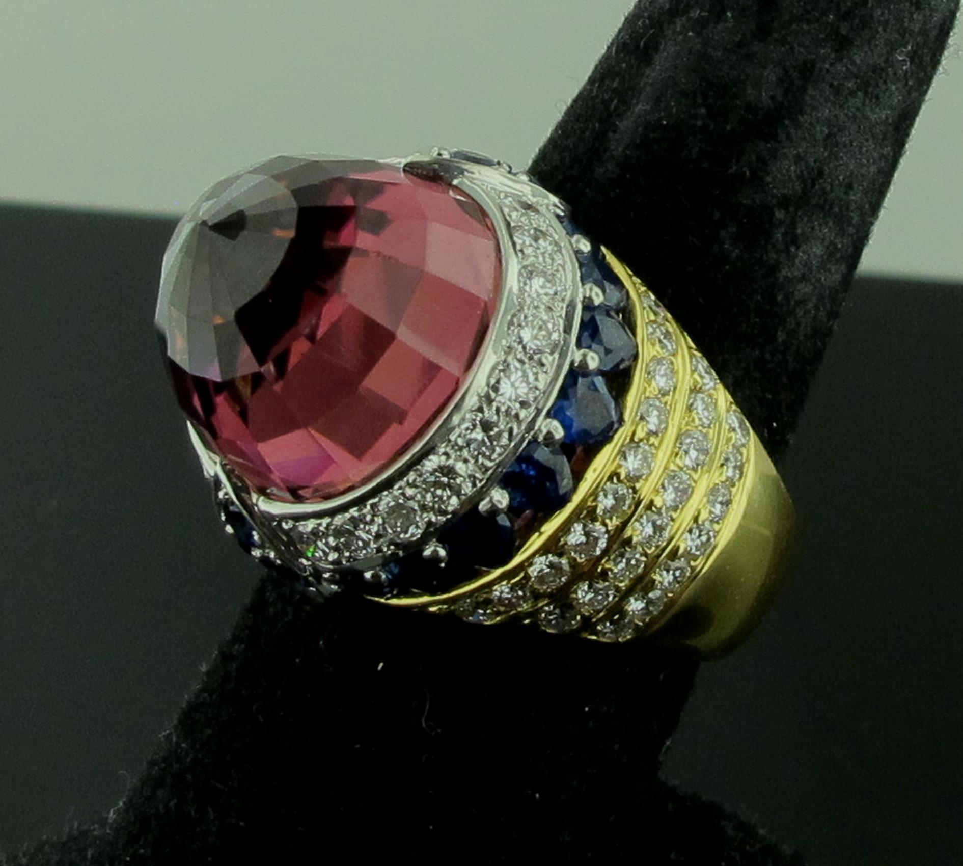 Set in 18 karat yellow gold and Platinum is one 20.35 carat Pink Tourmaline with 22 round cut blue Sapphires with a total weight of 5.01 carats and 70 round brilliant cut diamonds with a total diamond weight of 1.80 carats.  18 grams.  Ring size is