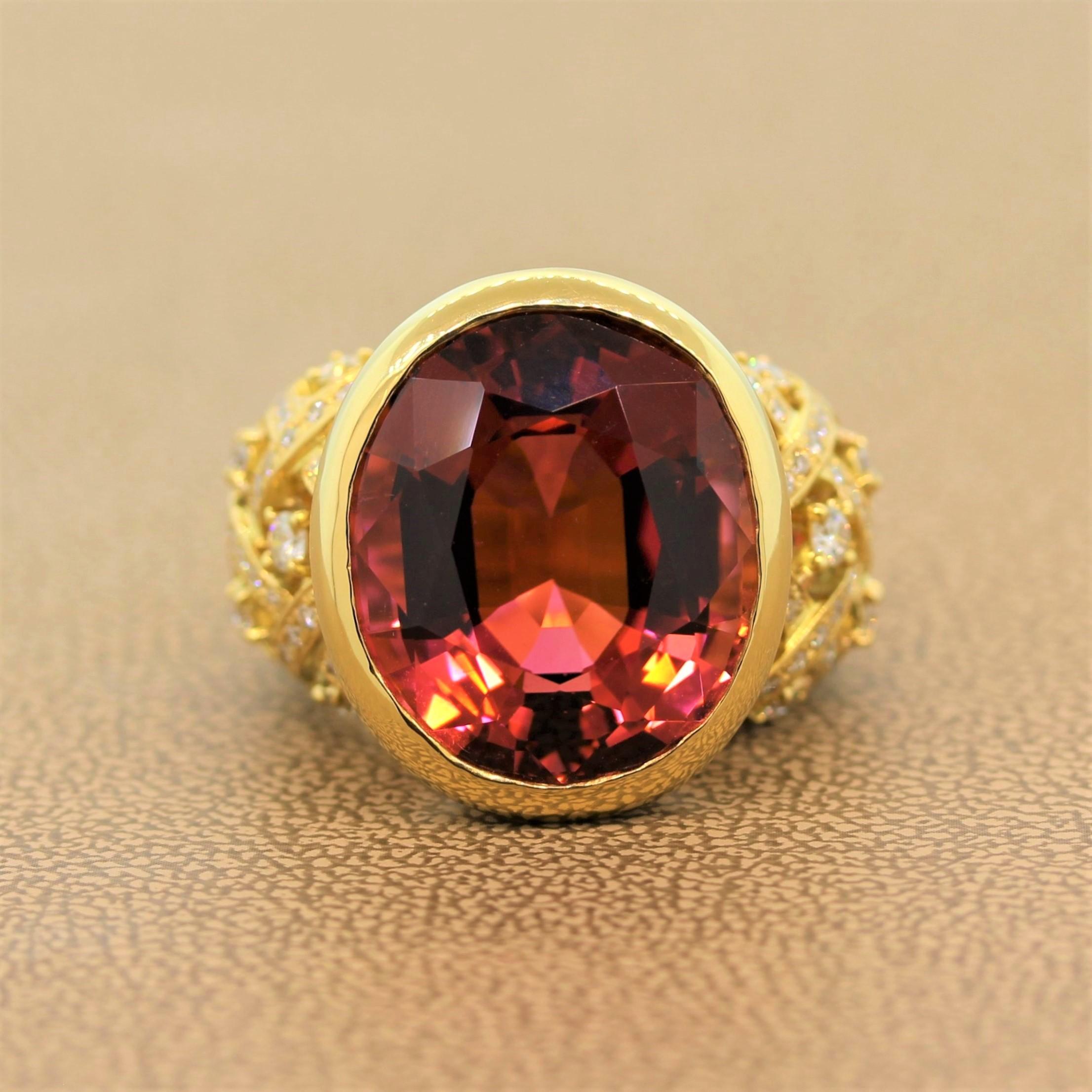 A cocktail ring featuring a captivating 21.37 carat oval shaped tourmaline. The pink gem is vibrant and eye clean. It is bezel set in an 18K yellow gold setting with 0.94 carats of round cut diamonds on the lattice designed shoulders. An exquisite