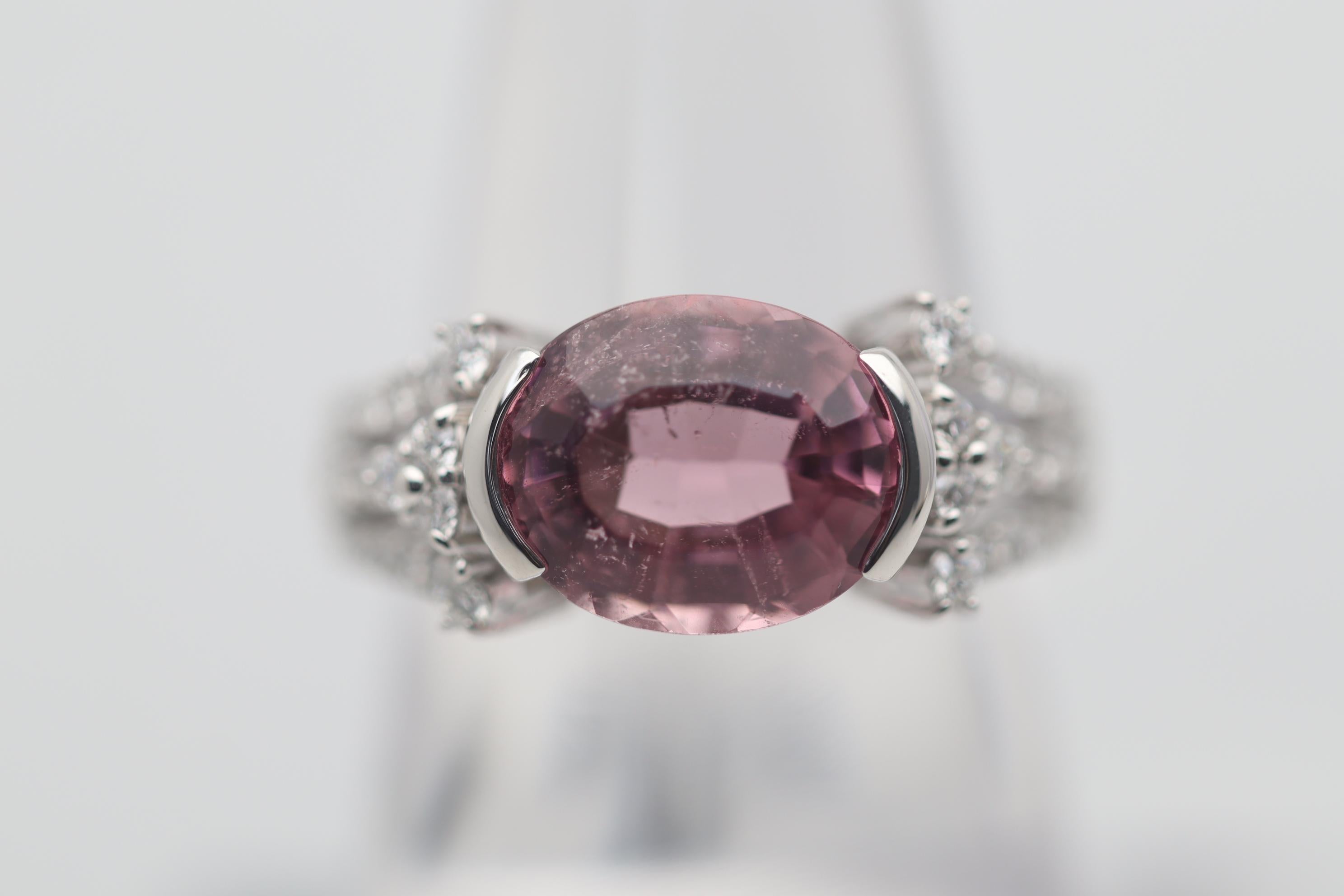 A sweet and stylish ring featuring a lovely pink tourmaline. It weighs 6 carats and has a rich pink color along with a unique step-cut on its crown. Complementing the tourmaline are 0.60 carats of round brilliant-cut diamonds set down the sides of
