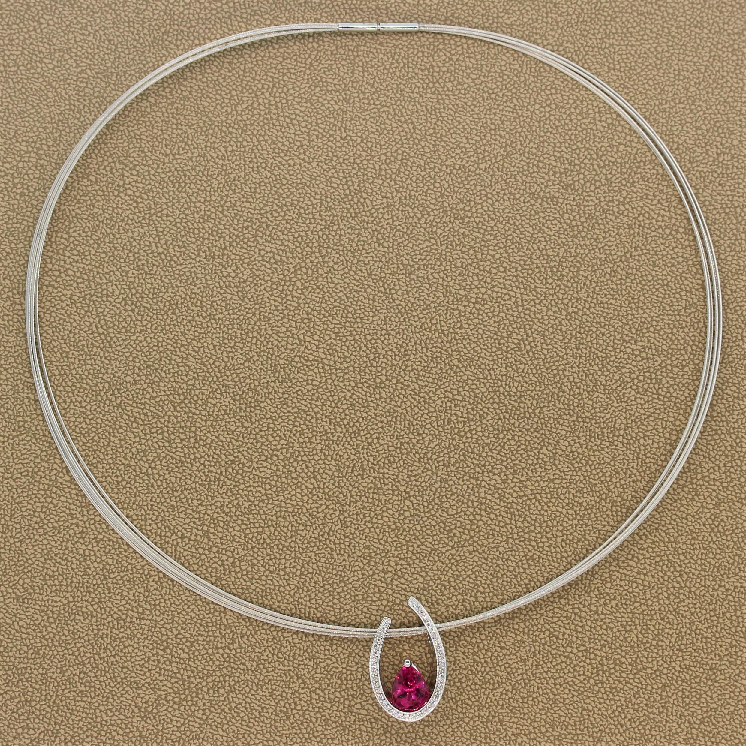 Un bellissimo ciondolo con una tormalina rosa vivida da 2,12 carati. La gemma femminile si trova con grazia alla base di un'incastonatura a ferro di cavallo in oro bianco 14K, tempestata da 0,21 carati di diamanti a taglio rotondo e con un disegno a