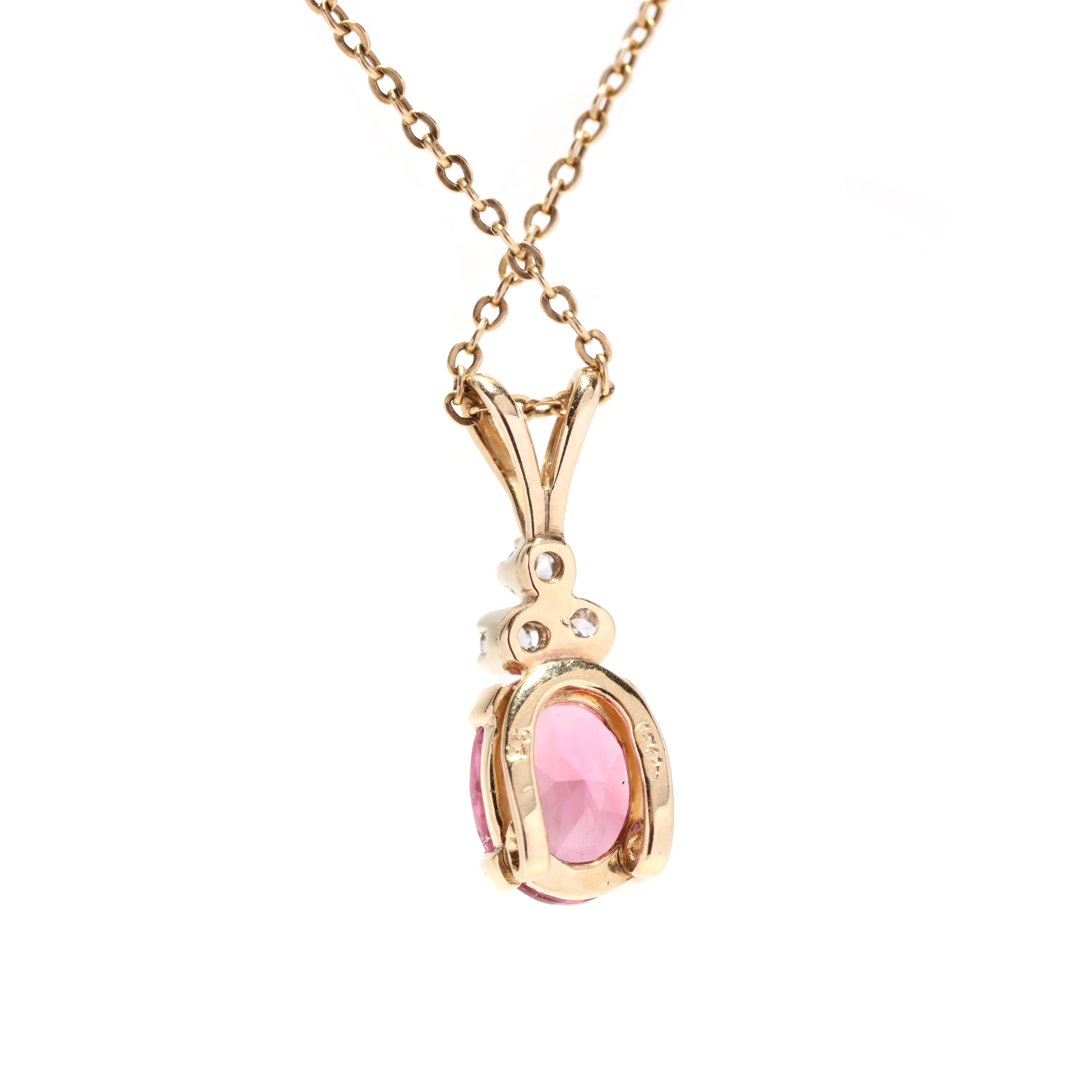 A vintage 14 karat yellow gold pink tourmaline and diamond pendant necklace. This necklace features a prong set oval cut pink tourmaline weighing approximately 2.10 carats with three diamonds set atop weighing approximately .09 total carats and