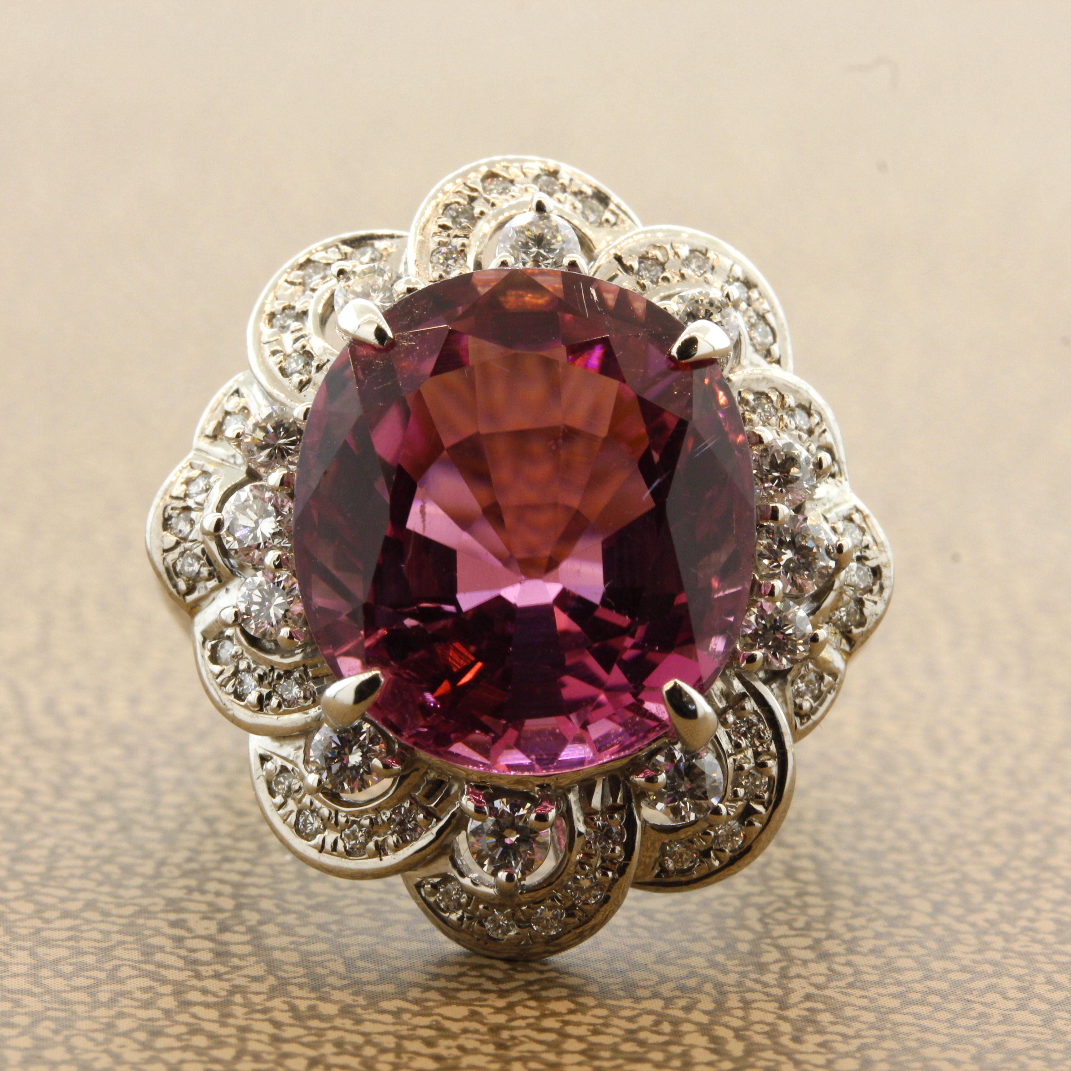 A large, fine, and impressive tourmaline weighing 13.61 carats takes center stage of this platinum made ring. It has a rich, even pink color with excellent clarity allowing the stone's natural color to shine free from any light blockage. It is