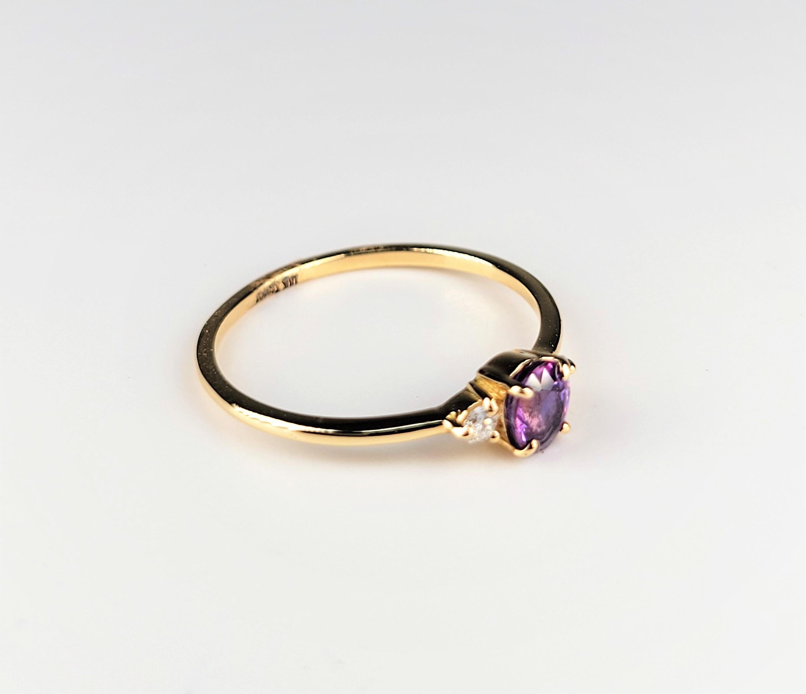 In 18 karat yellow gold, this lovely 3 stone ring is centered with an oval-shaped pink tourmaline, which is flanked by diamonds. 