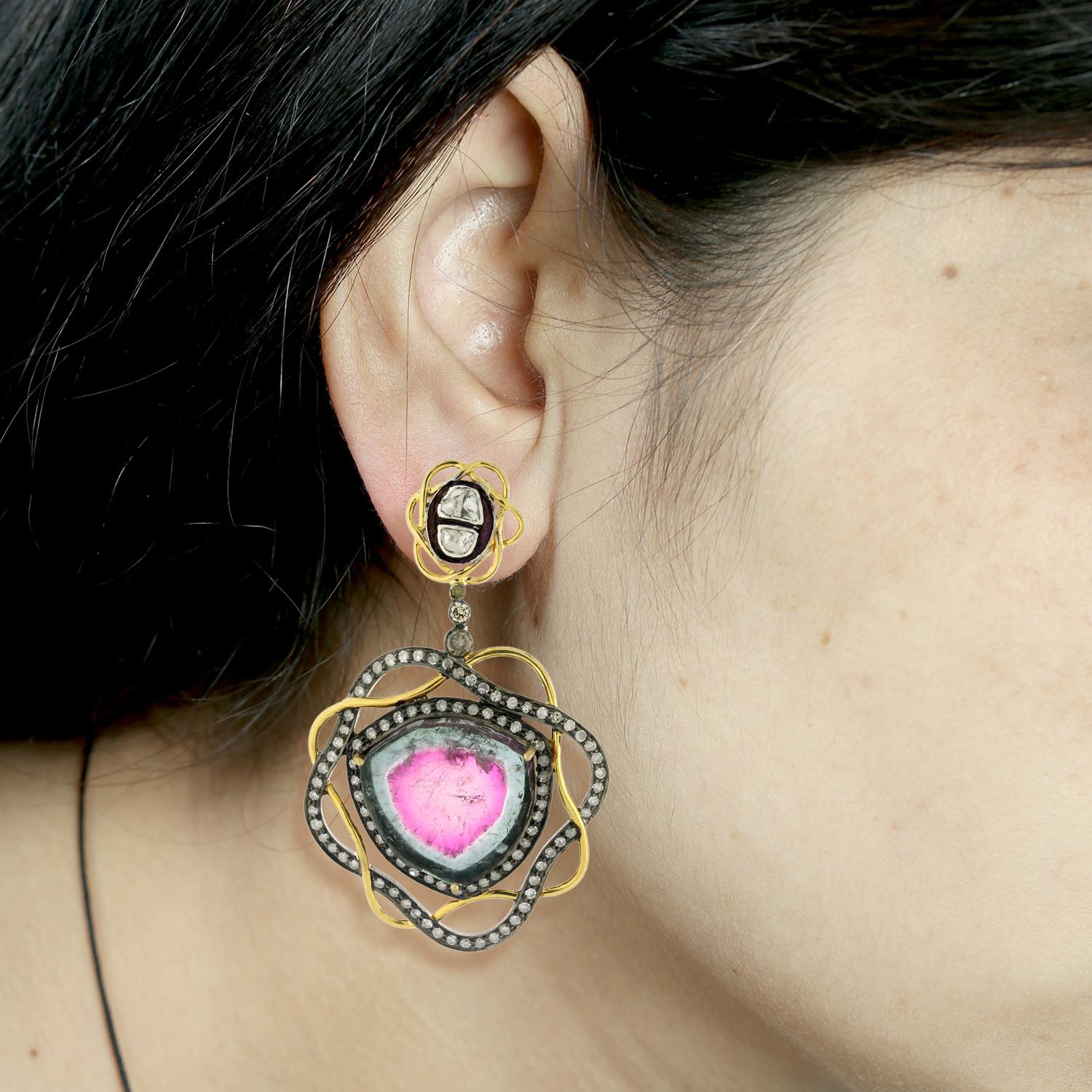 This pink tourmaline earring enclosed in pave diamonds set in 18k gold and silver is a stunning and unique piece of jewelry. The pink tourmaline gemstones add a pop of vibrant, feminine color to the earring, while the pave diamonds add a touch of