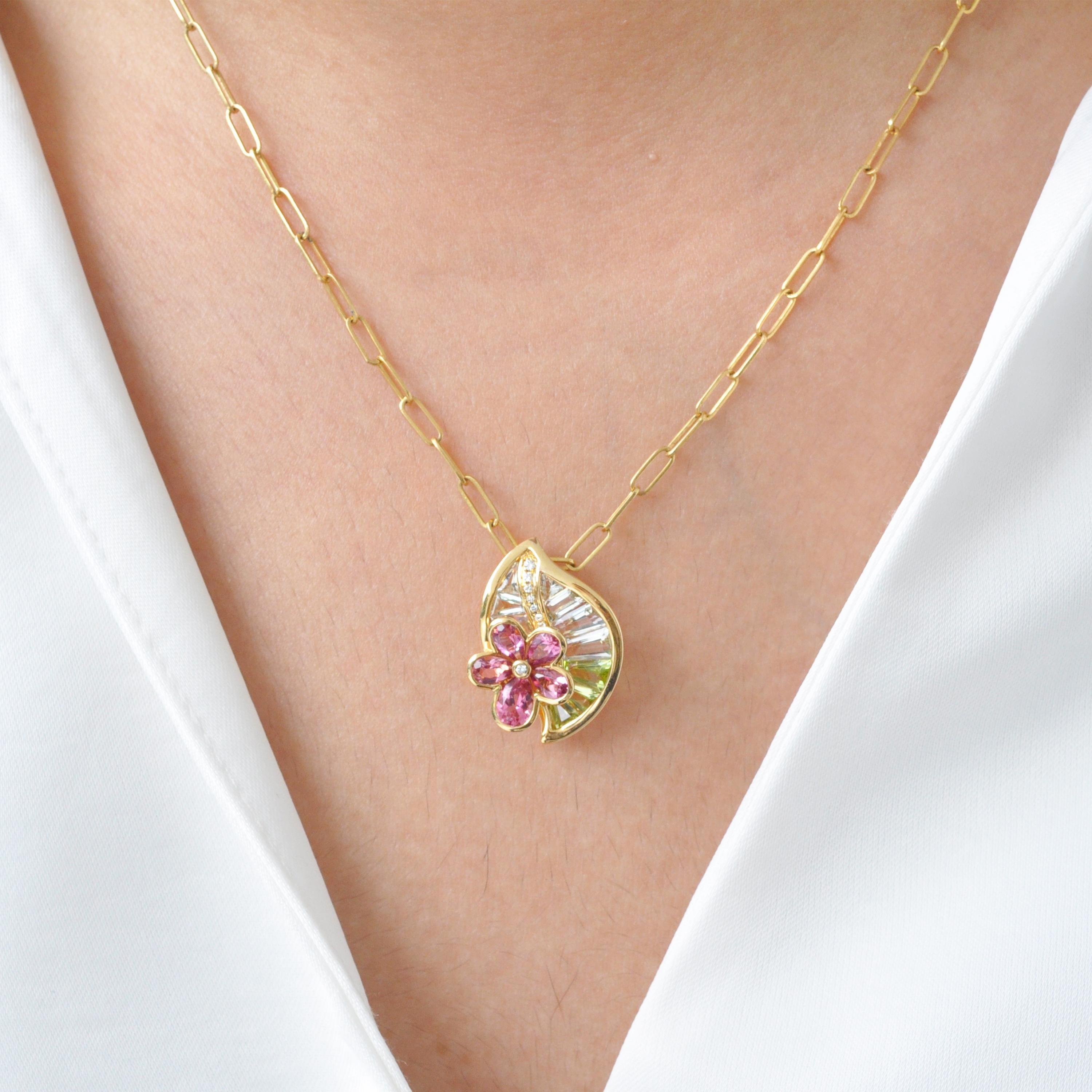 Questo affascinante ciondolo floreale, realizzato in oro giallo 18 carati, cattura magnificamente l'armonia della natura attraverso una raffinata miscela di colori, forme e brillantezza. Disegnato come una graziosa foglia che culla un fiore