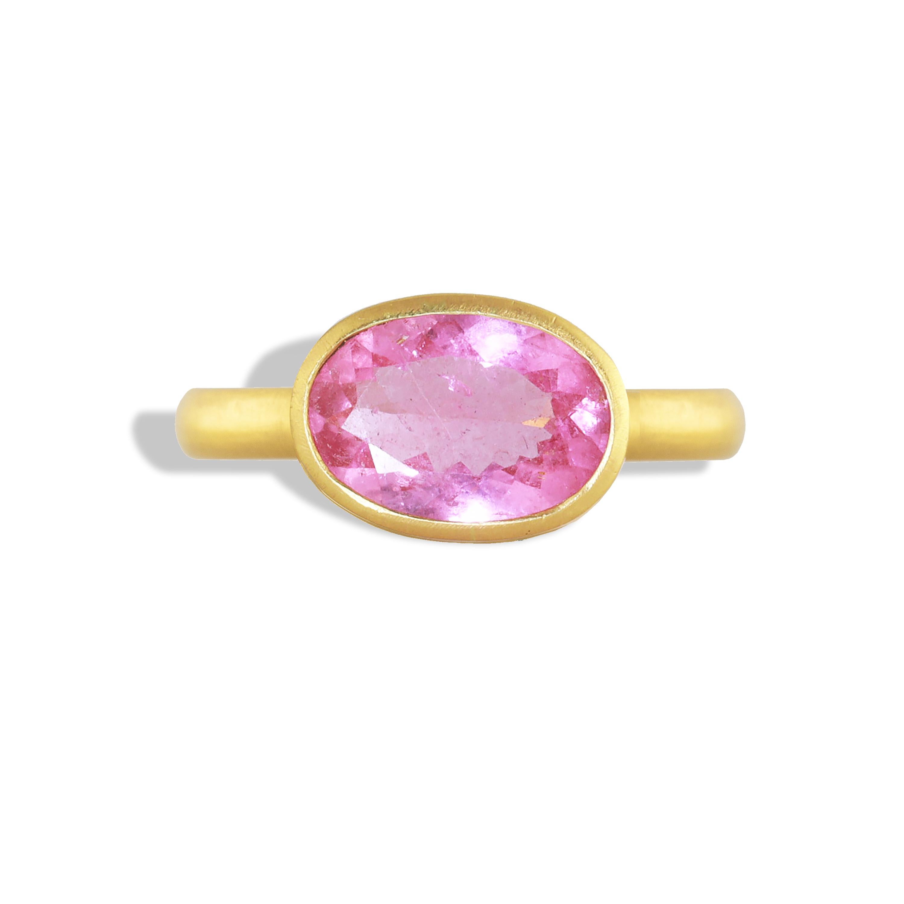 A stand-out 3.52 carat hot pink oval tourmaline is framed in a jali setting of 22k gold. The saturated, pink rose color of the stone peeks through the jali wave cut-outs along the sides. 
Pink tourmaline is said to inspire love, spirituality and