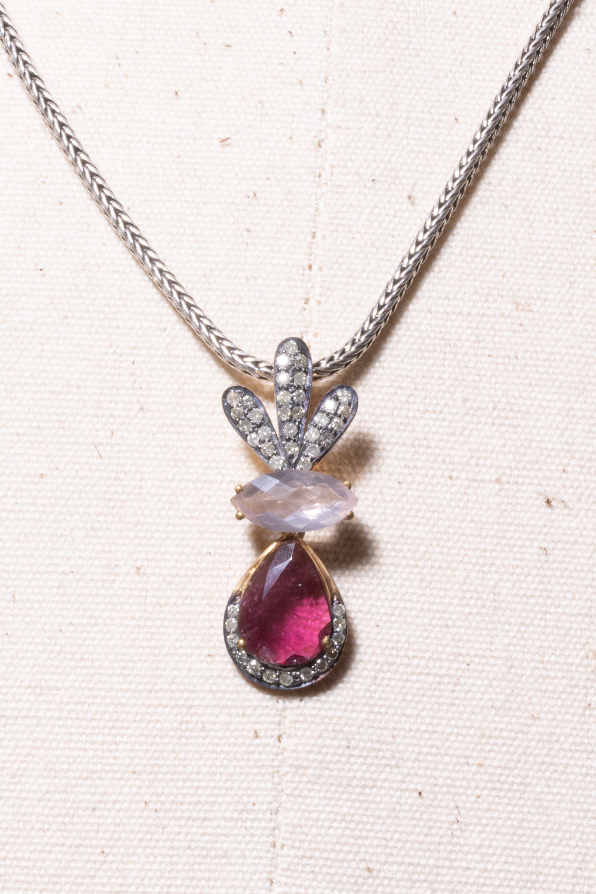 Pendant necklace with a pear-shaped, faceted pink tourmaline gemstone bordered with round, brilliant cut diamonds.  A marquise, faceted rose quartz is mounted above and a crown of diamonds above that in a pave` setting.  Set in sterling silver.  The