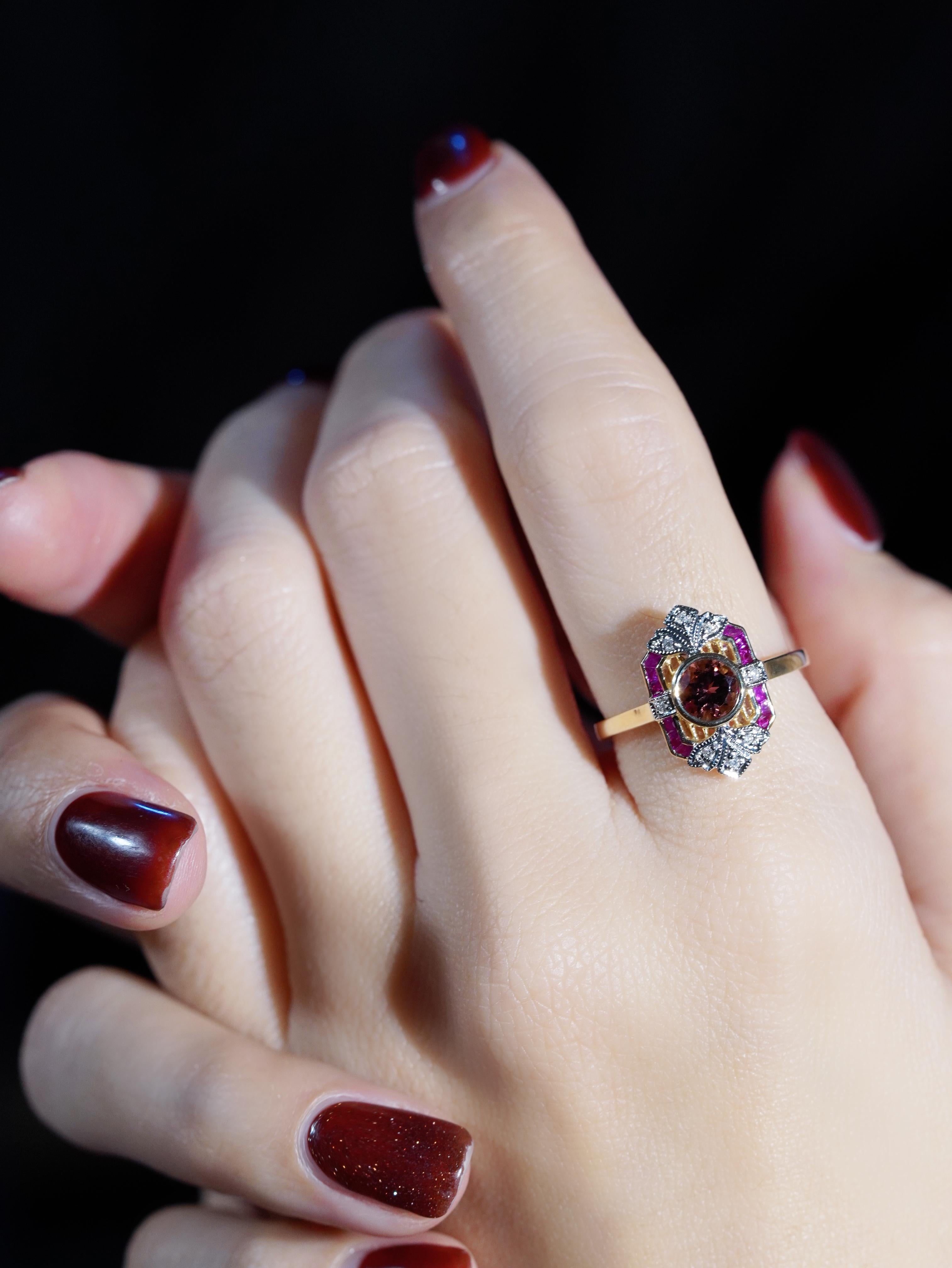 Cette bague de fiançailles de style Art déco est un véritable coup de cœur. Une tourmaline rose incandescente occupe le devant de la scène dans une monture élégante, rayonnant d'une élégance féminine à chaque regard. Rehaussé de diamants étincelants