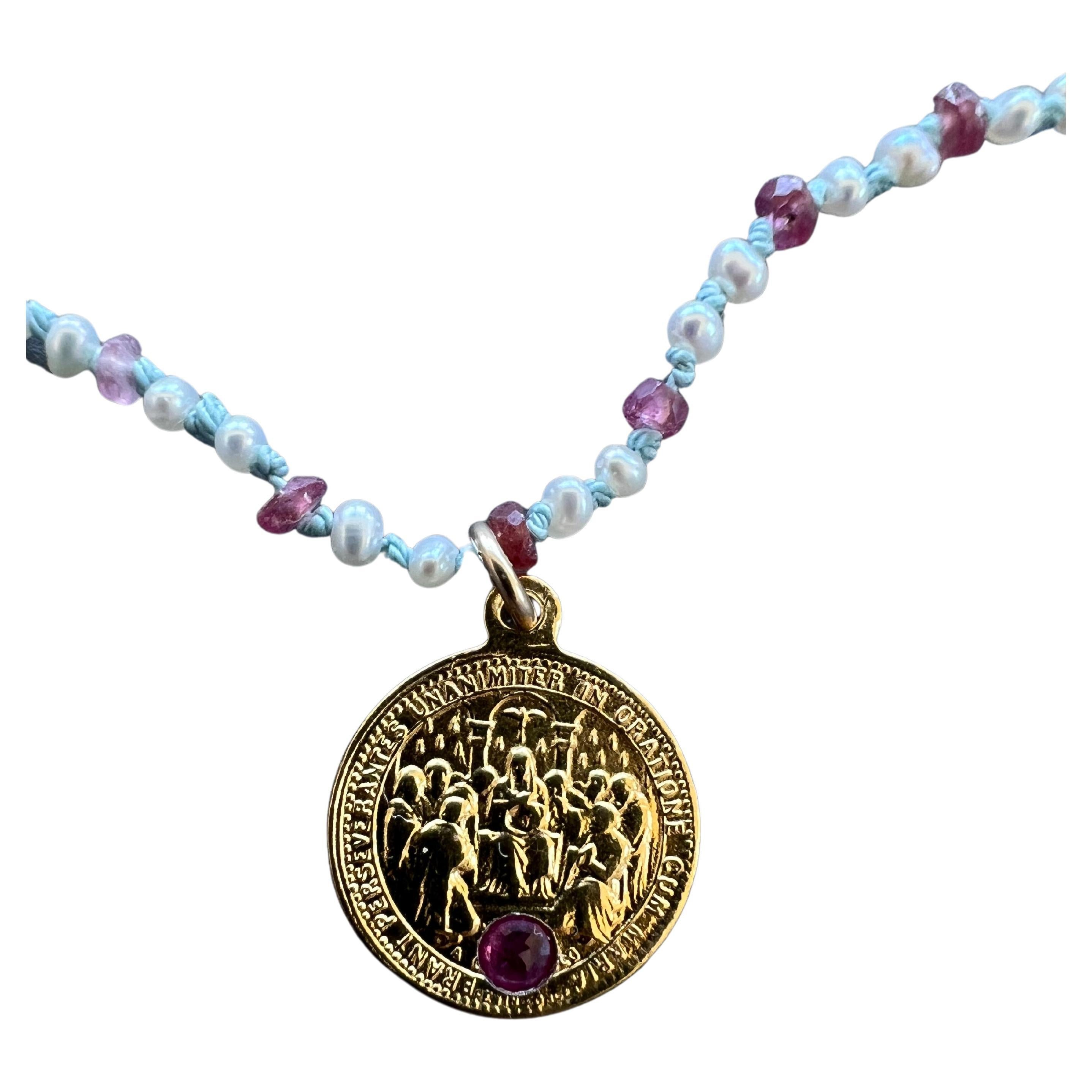 Tourmaline rose sertie dans une médaille du Sacré-Cœur en plaqué or avec un Whiting composé de perles blanches, d'opales et de rubis perlés avec des nœuds de soie bleu clair entre les deux. Il s'agit d'une pièce unique.
Collier ras-de-cou 16