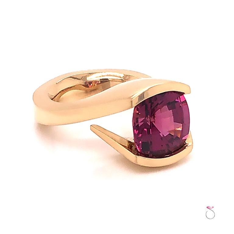 Stunning large pink tourmaline ring in 14k yellow gold. This ring features a beautiful cushion shape with checkers faceting. The rich pink Tourmaline center set in a semi bezel where the ring wraps around the center. The pink tourmaline measures