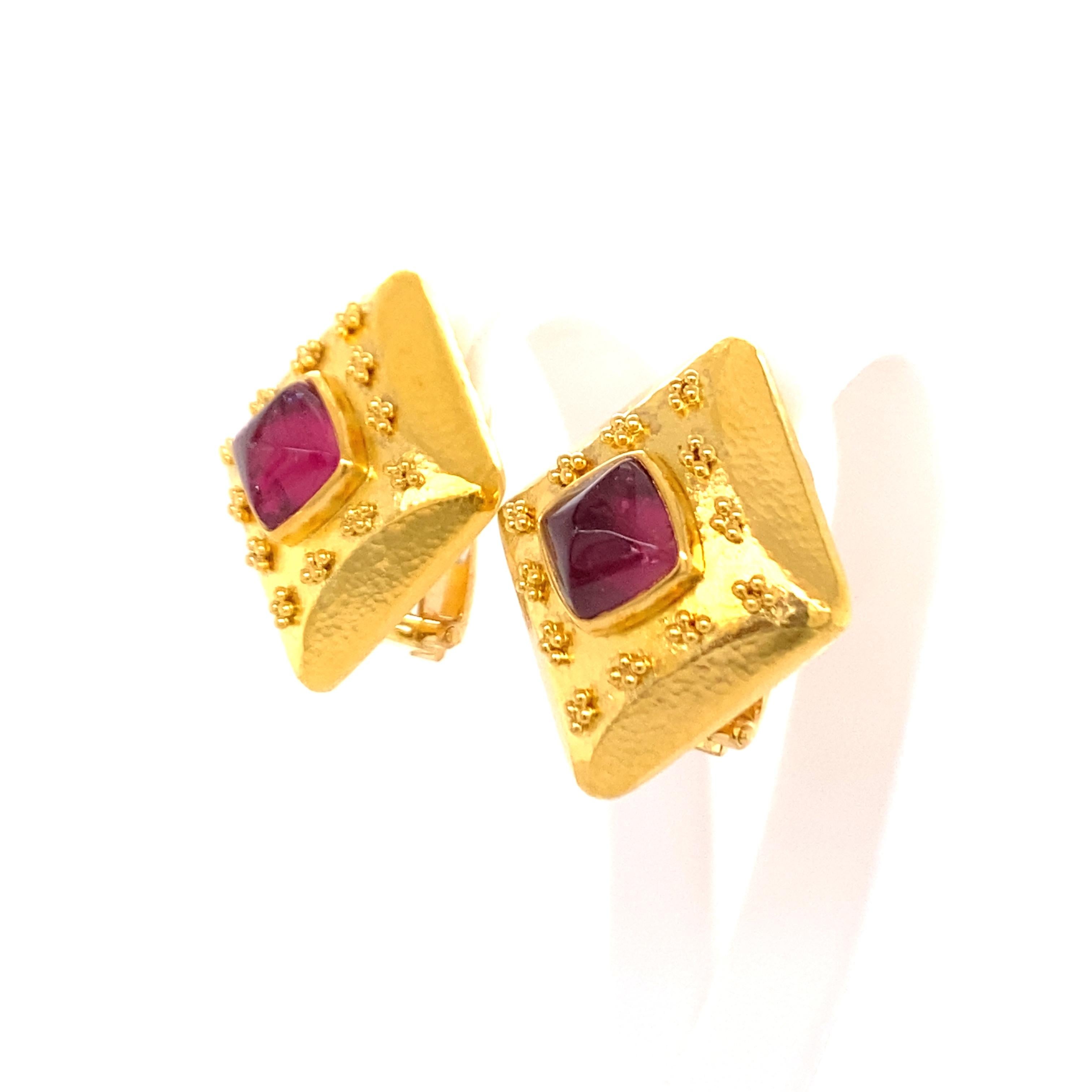 This beautiful pair of earclips features two sugarloaf cabochon cut pink tourmalines with a total weight of approximately 3.00 carats. The setting in rich 18 karat yellow gold is decorated with a fine granulation entourage, reminiscent of the high