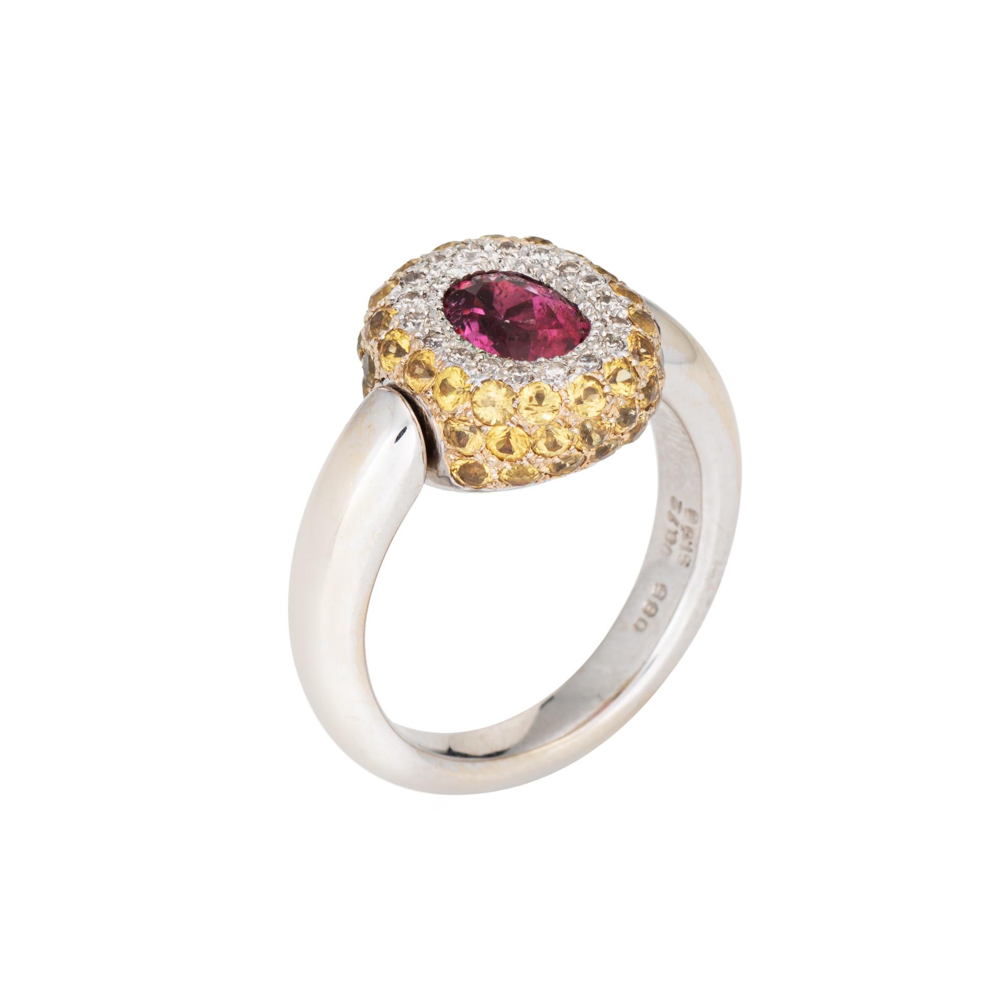 Stilvoller zeitgenössischer Ring aus 18 Karat Weißgold mit rosa Turmalin, gelbem Saphir und Diamanten (ca. 2000er Jahre).

Der facettierte, oval geschliffene rosa Turmalin in der Mitte hat schätzungsweise 0,85 Karat. Die gelben Saphire haben einen