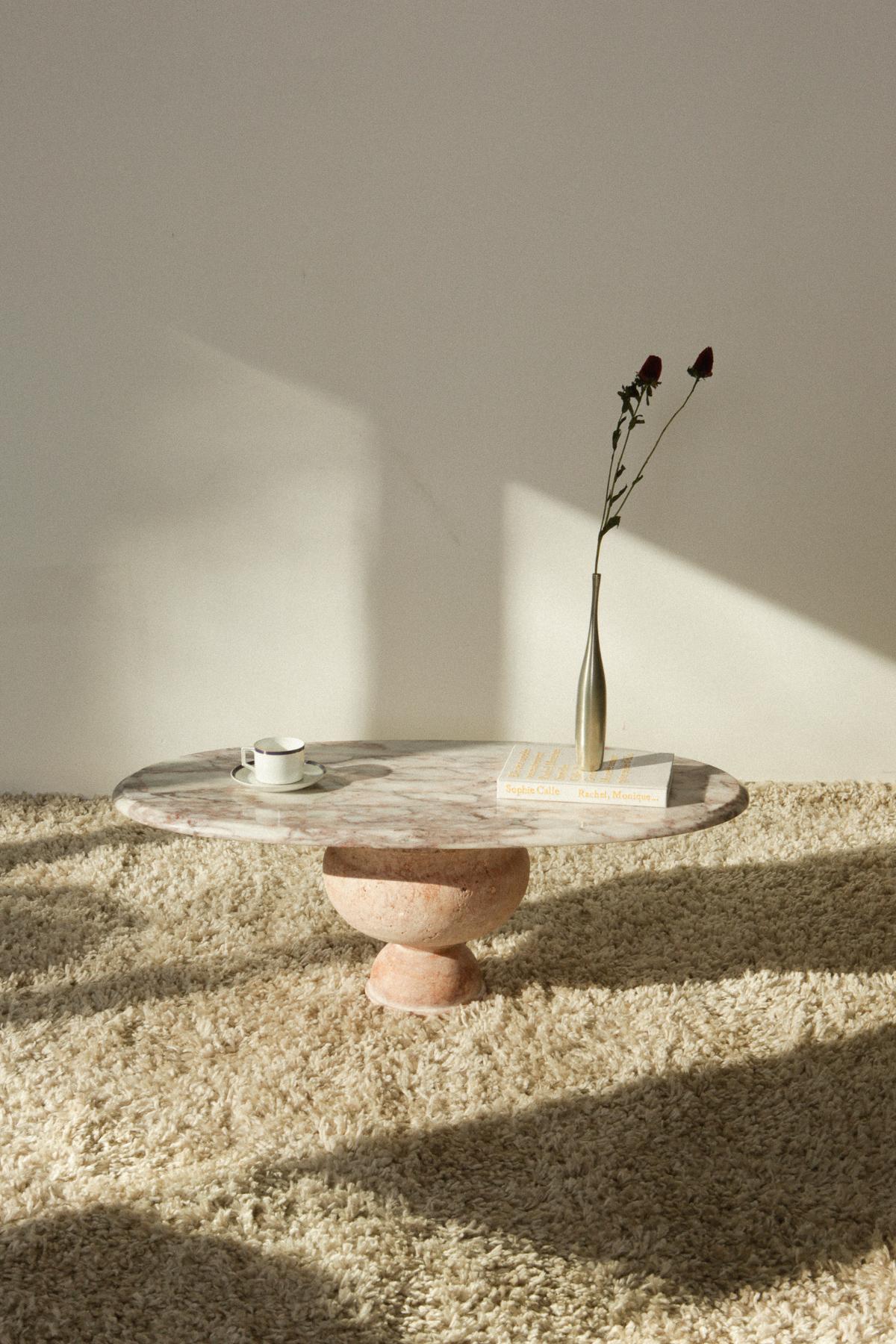 This piece was created by NVT Studio from the highest quality remnant stone, and is the only one in existence. Threads of pink layer with white and silver hued marble on this oval shaped table top creating a romantic, soft feel. The base is made of