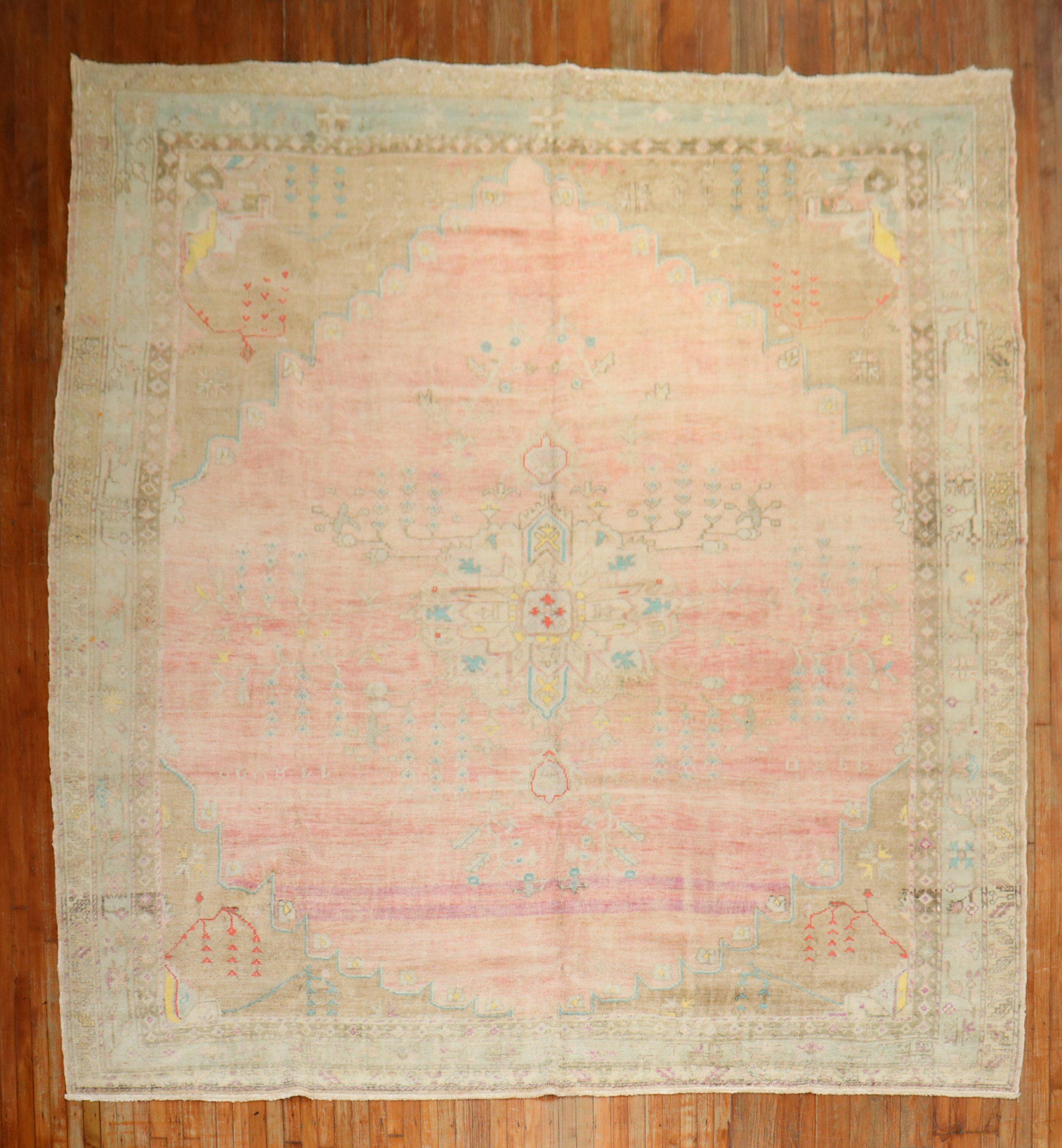 A vintage Turkish rug with a central medallion on a pink field. accents in yellow, purple brown, beige and electric blue

Measures: 10'9'' x 12'5''.