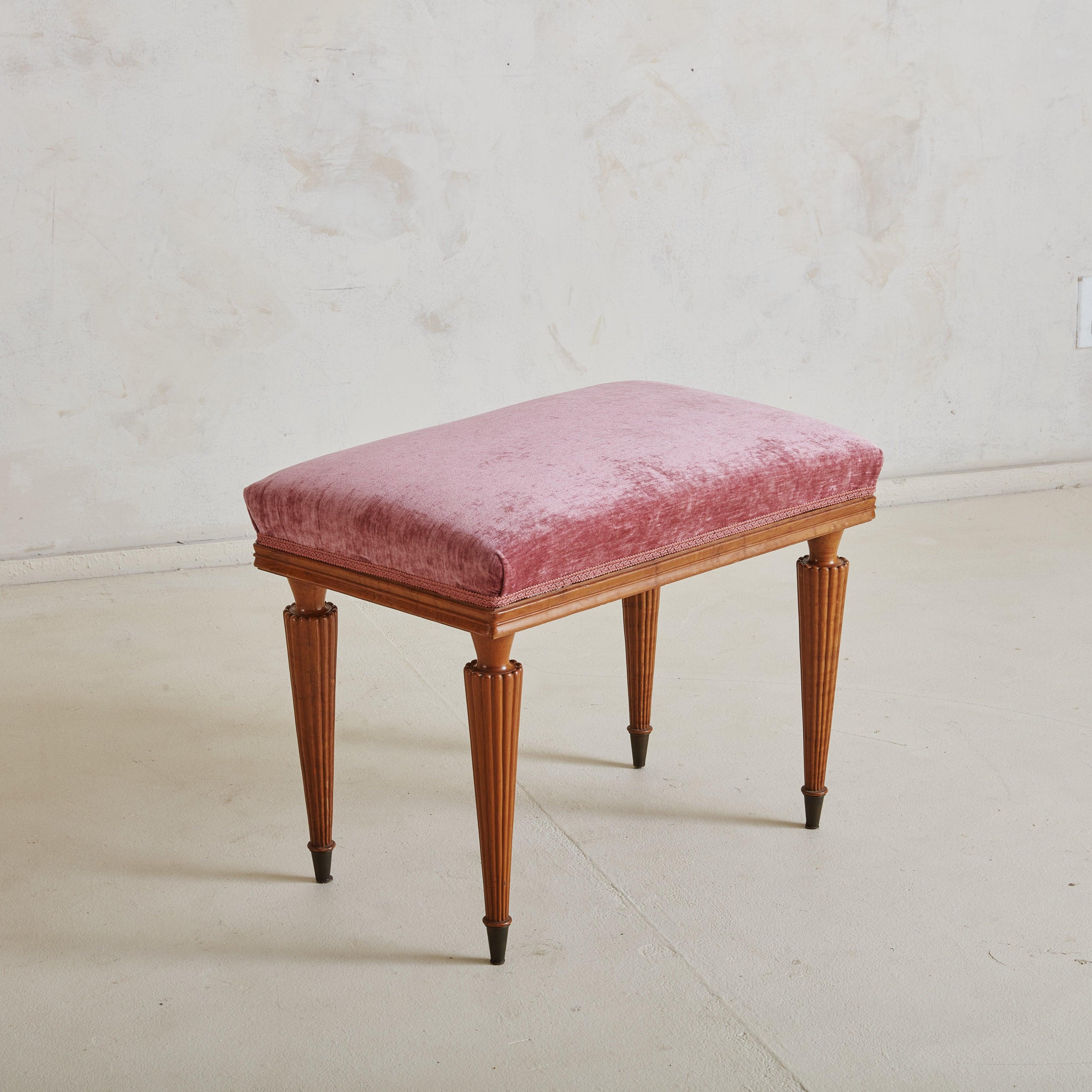 Precioso banco italiano de los años 70 con suave tapizado de terciopelo rosa y detalles decorativos. El banco se apoya en patas de madera delicadamente estriadas, cada una de ellas afilada y rematada con sutiles casquillos de latón. Este encantador