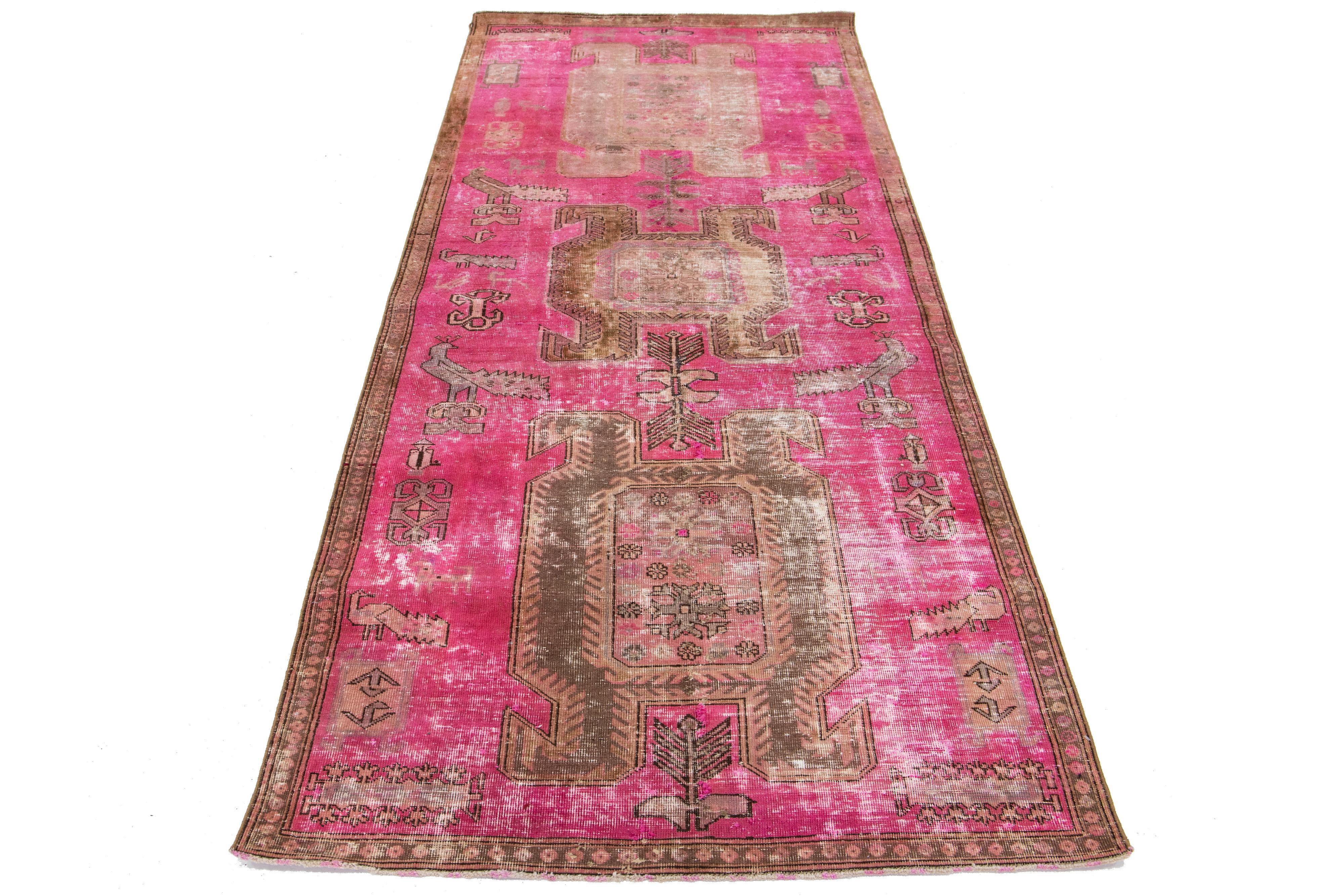 Dieser Vintage-Teppich aus persischer Wolle zeigt ein rosa Feld mit grauen Stammesakzenten.

Dieser Teppich misst 3' 9