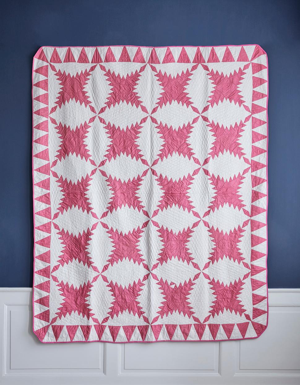 Lovely pink and white feathered stars cotton quilt. The quilt is hand pieced and hand quilted with a nice pyramid border.