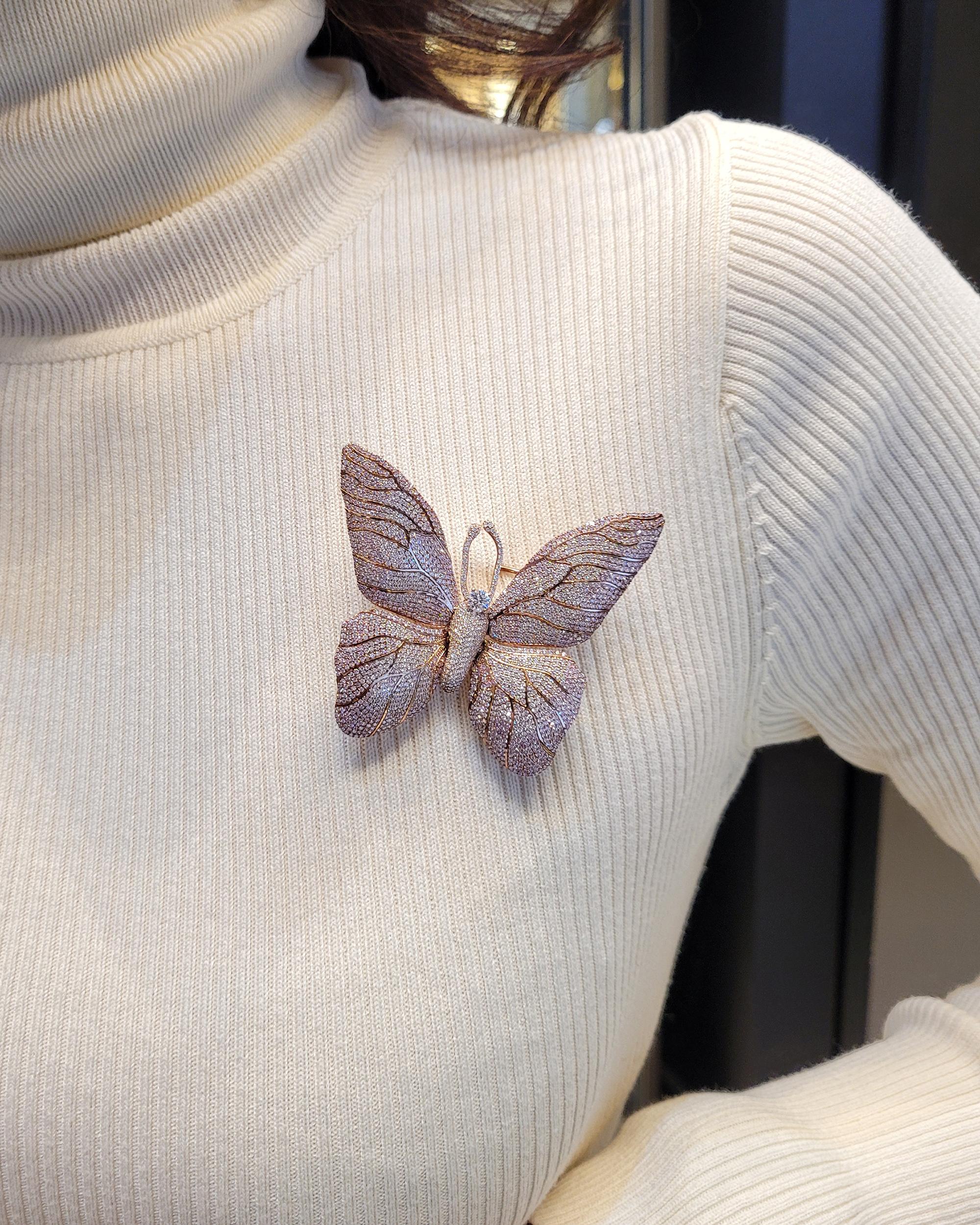 A butterfly brooch made 'en tremblant' with white and pink diamonds, by Spectra Fine Jewelry.
817 white diamonds weighing 3.46 carats. 
928 pink diamonds weighing 4.15 carats.
Metal is 18k rose gold, gross weight is 33.05 g.
Measurements:
W: 2.5