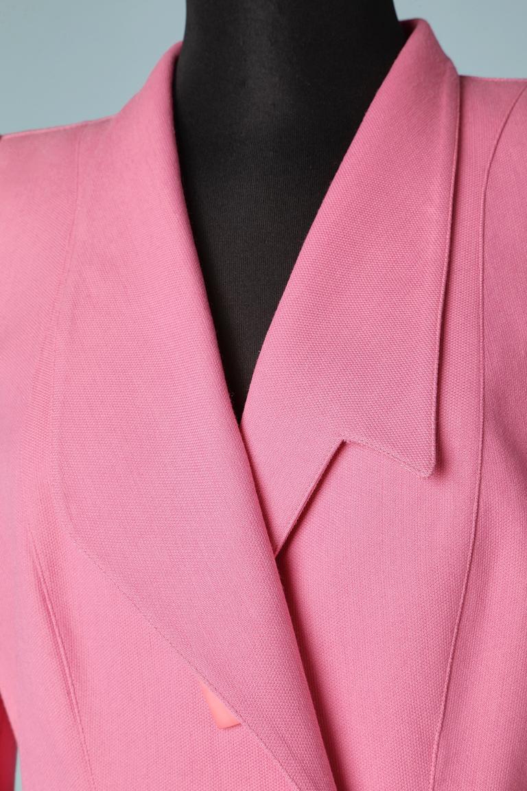 Pink wool asymmetrical double-breasted skirt suit. Snap to close the jacket in the middle front and inside button and buttonhole. Wrap skirt in the back. Shoulder pads.
SIZE M