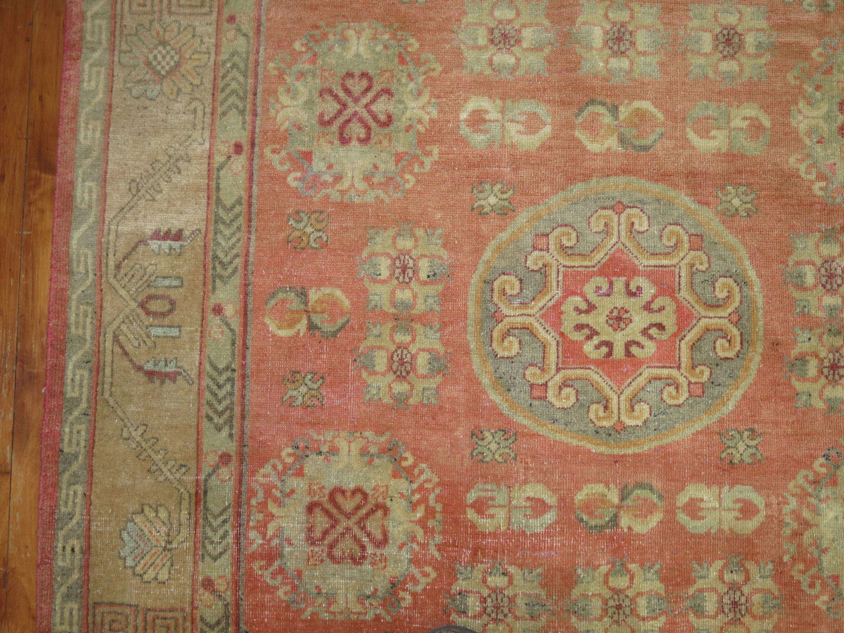 One of a kind early 20th century Khotan rug with a soft pink field consisting of a yin yang pattern and a camel border.

Measures: 5'4'' x 8'3''.