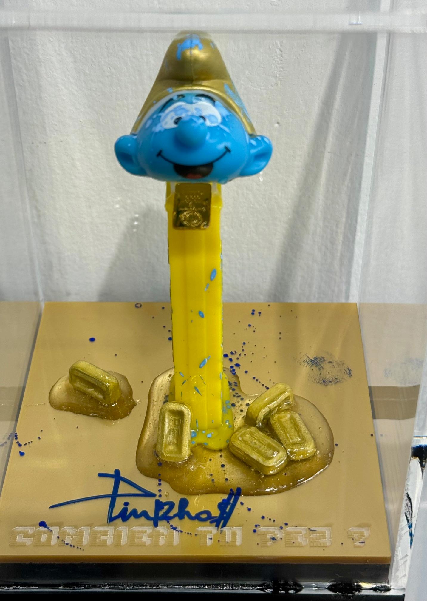 Sculpture combining a Plexiglass box displaying a plastic/resin character enhanced with acrylic paint and real customized candies are scattered around the base of the sculpture.

Instead of delivering candies the mouth of the character exhibits a