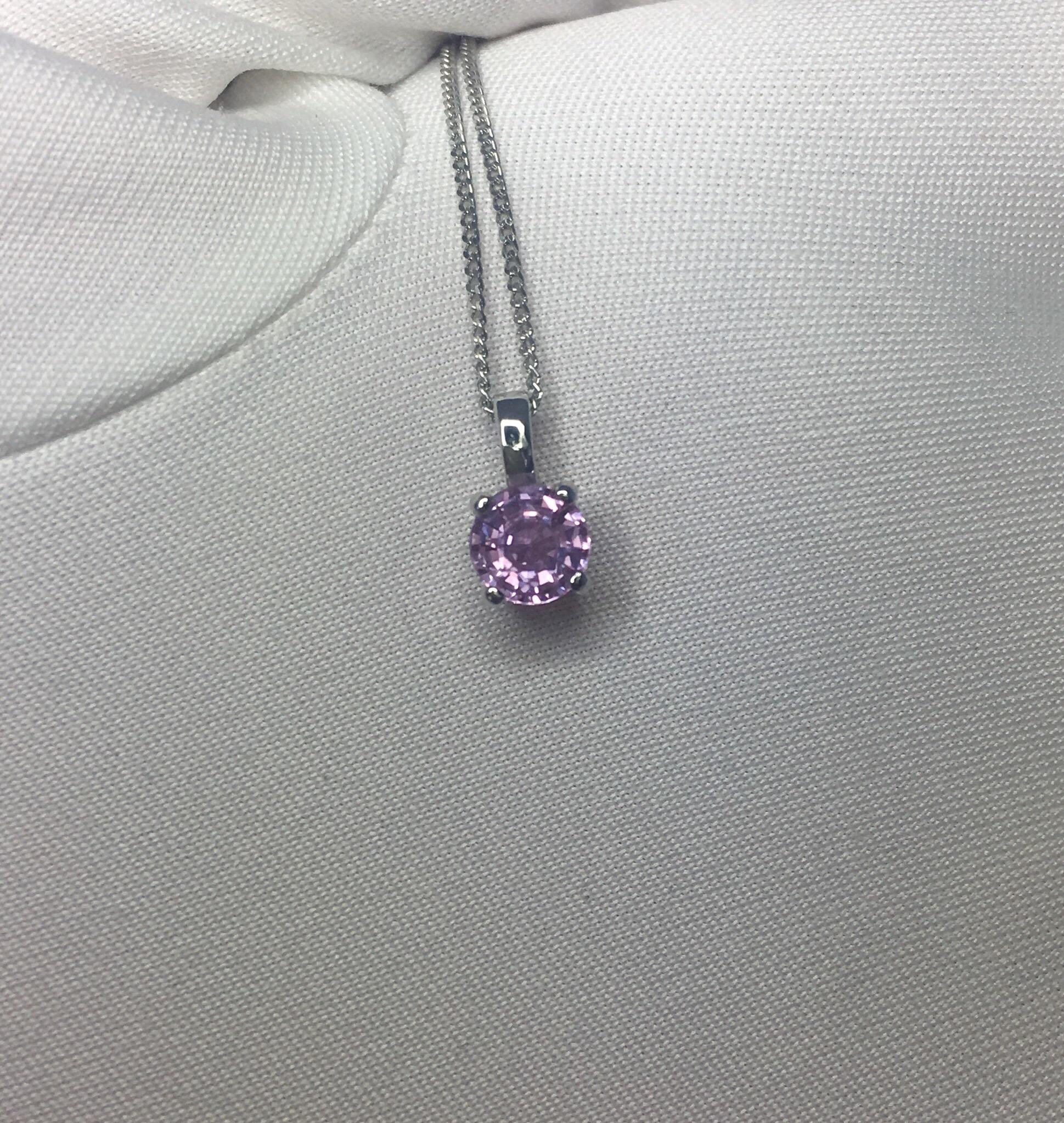 Natural vivid pinkish purple unheated sapphire solitaire pendant.

Beautiful round cut Sapphire. Set in a fine platinum pendant setting.

0.61 carat stone with a vivid pinkish purple colour and very good clarity.

The pendant is hanging on a 16