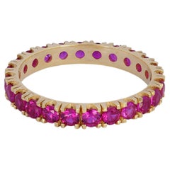 Anillo de eternidad de oro de 14 quilates con gema rojo rosáceo.