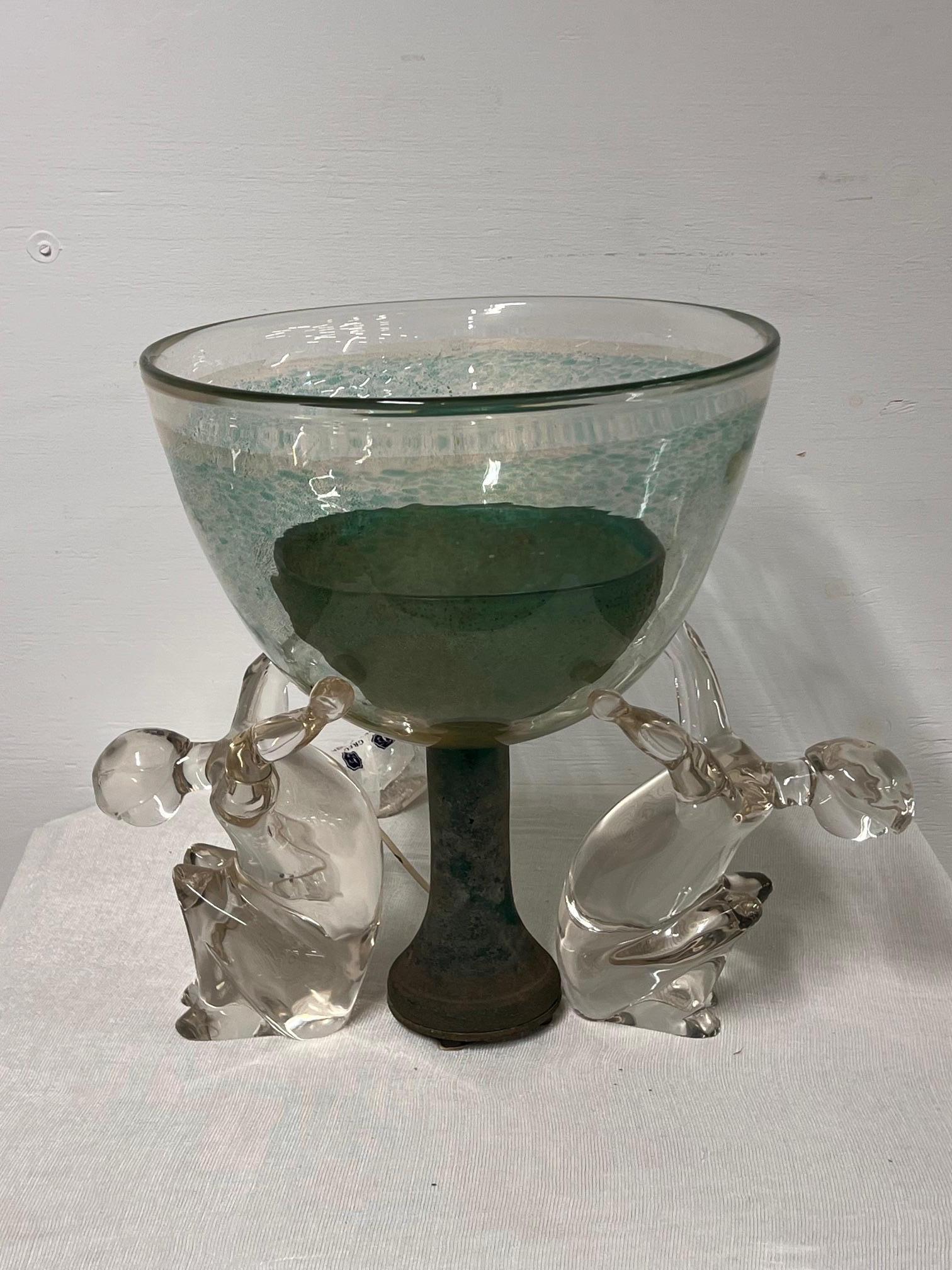 Pino Signoretto and Franca Petroli Murano glass sculpture-lamp
early 1980s. 
Central cup supported by two transparent glass figures, it has a light, and the designers' pointed signature is at the base of the cup.
Needs to be rewired 